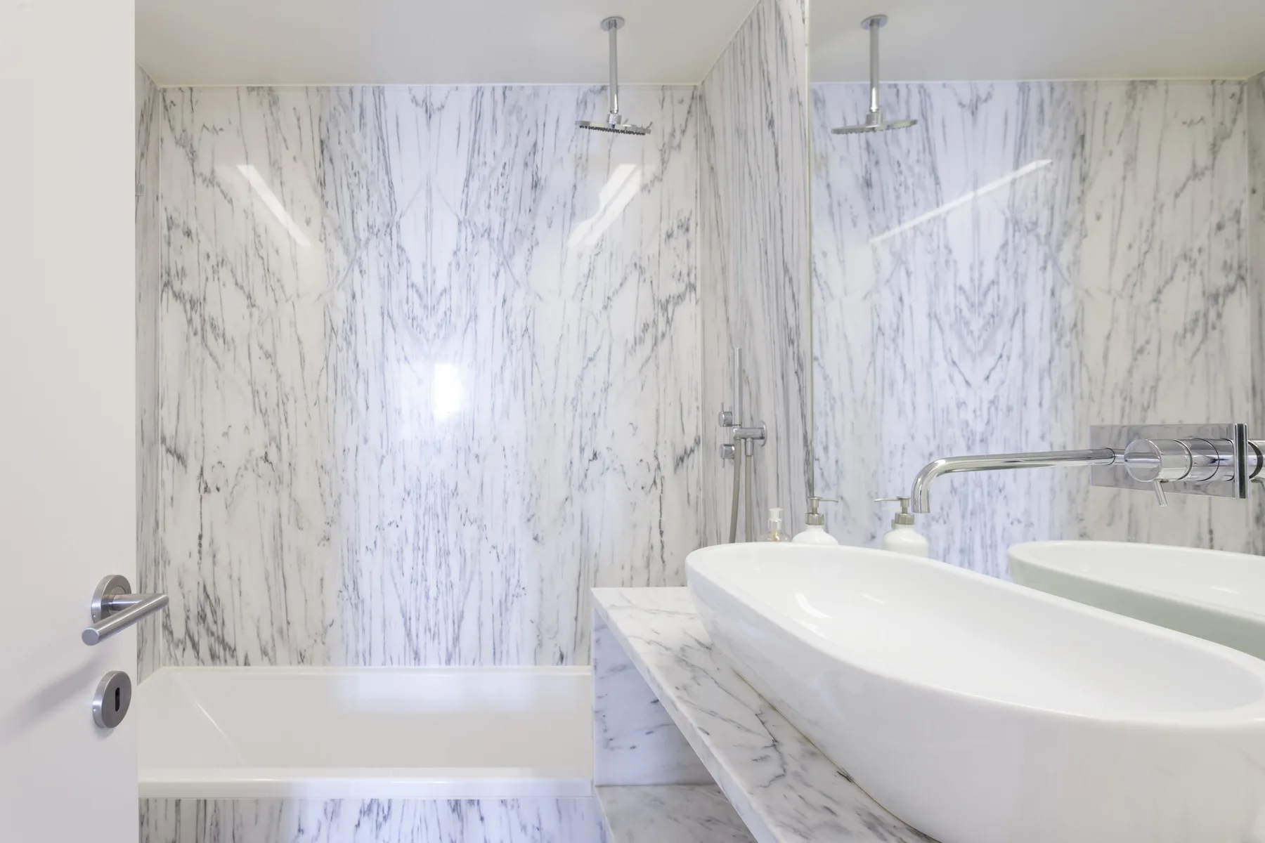 A bright bathroom with a bathtub and a large sink.