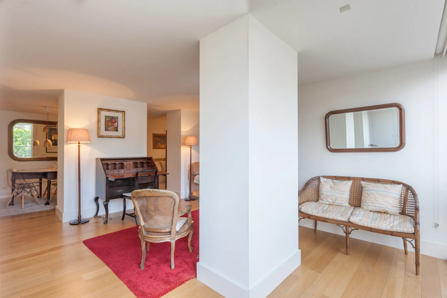A bright living area with seating, a fireplace, and light wood flooring.