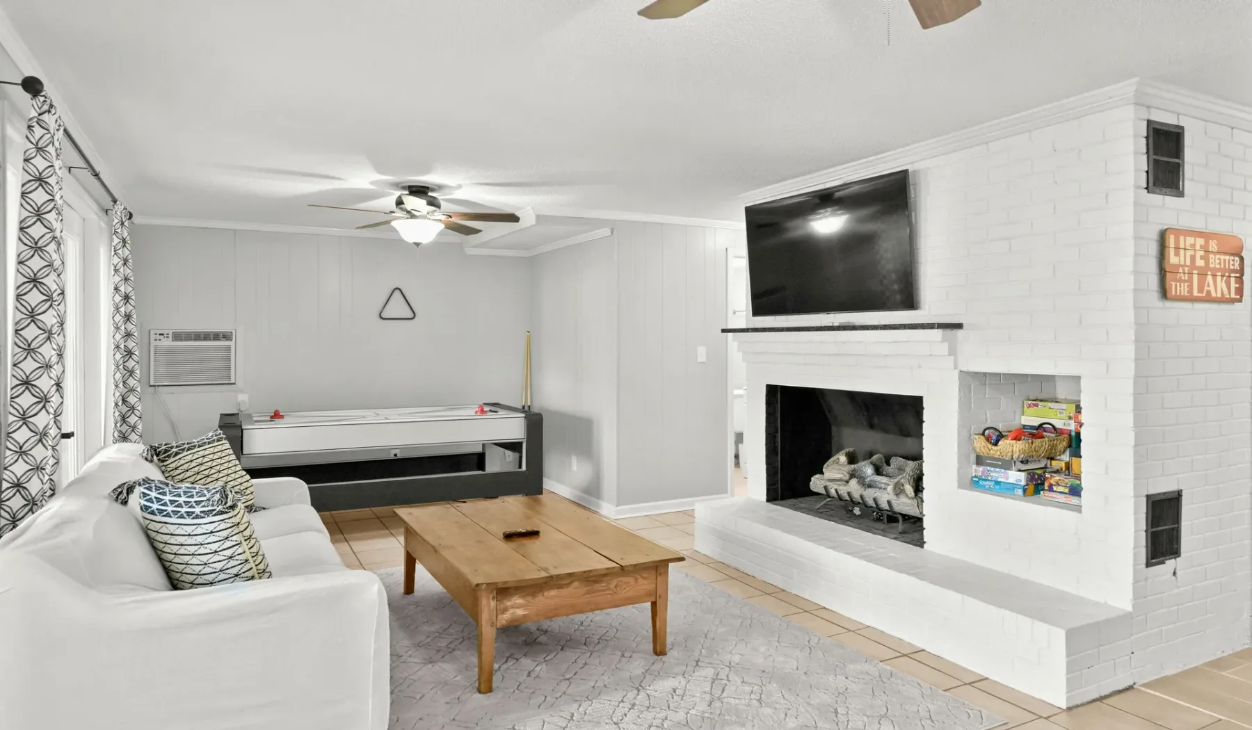 Una sala de estar con zona de asientos, mesa de centro y chimenea.