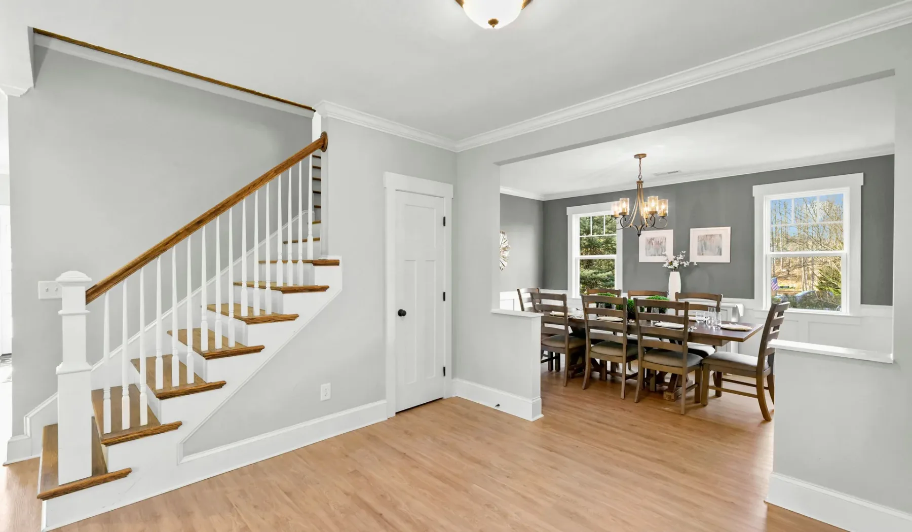 Un comedor con una mesa y sillas está junto a una escalera.
