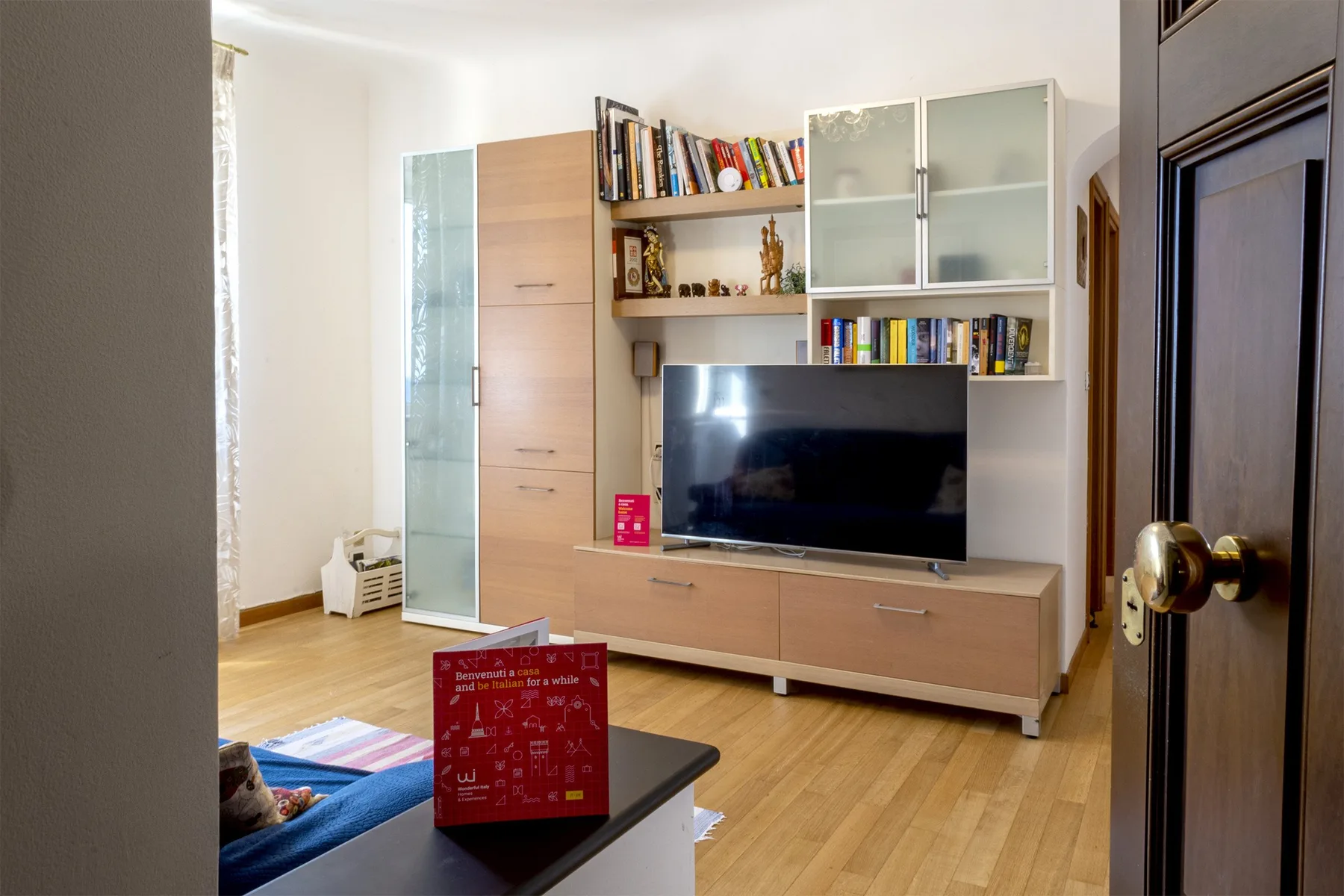 Una sala de estar con un televisor y estantes empotrados sobre muebles bajos.