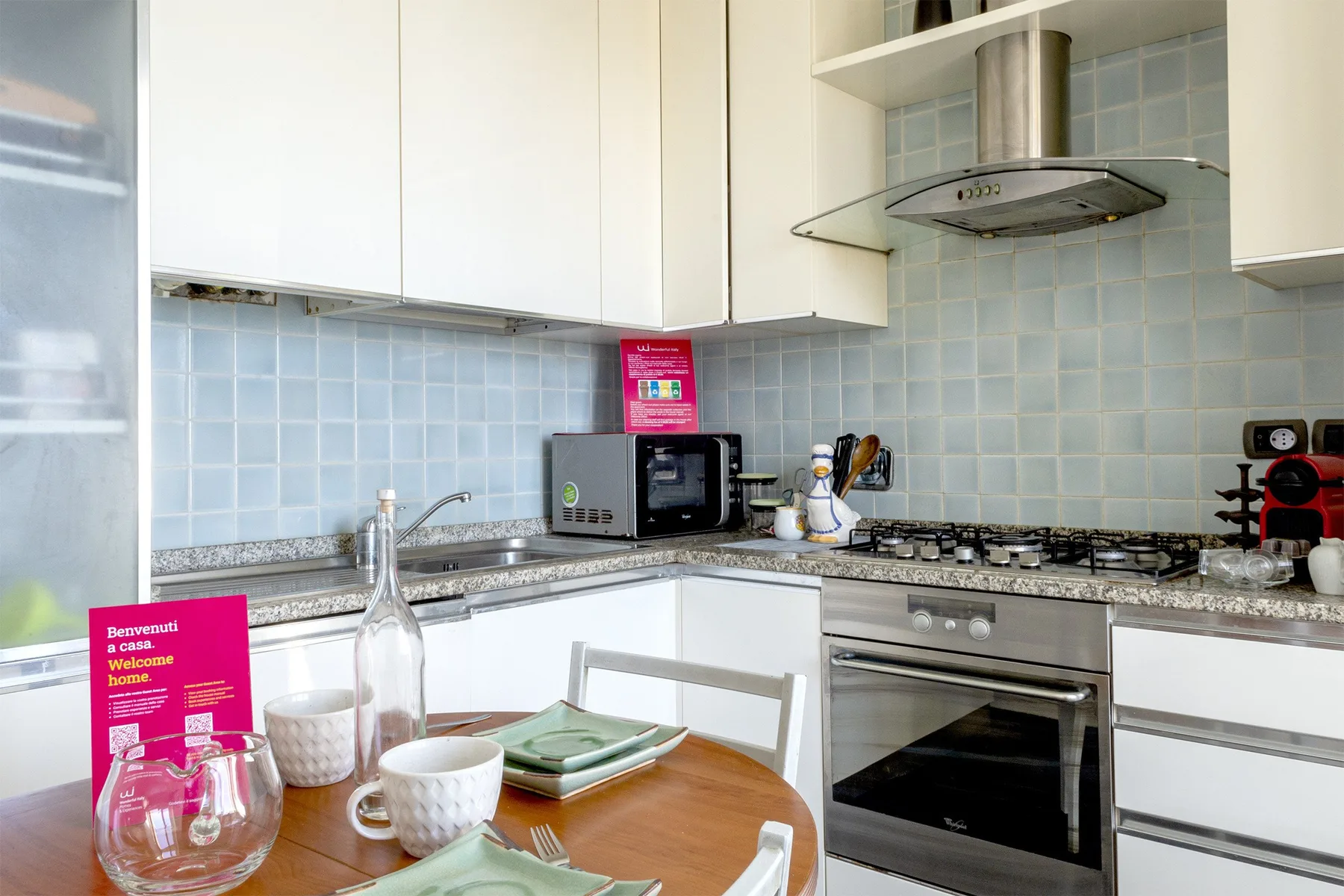 Una cocina luminosa con armarios claros, un salpicadero de azulejos y una mesa redonda.