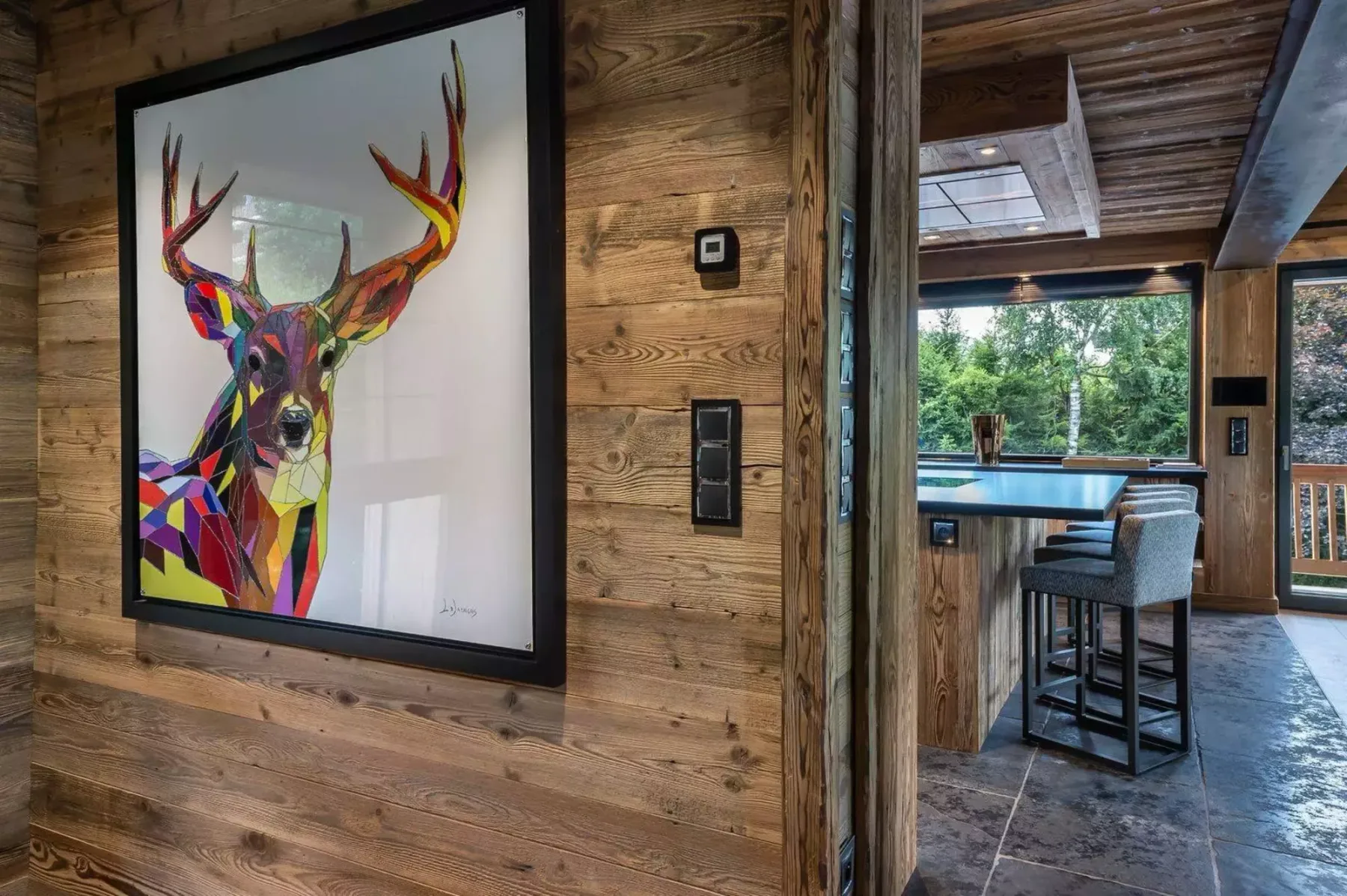 A wood-paneled interior opens onto a dining area with a large window.