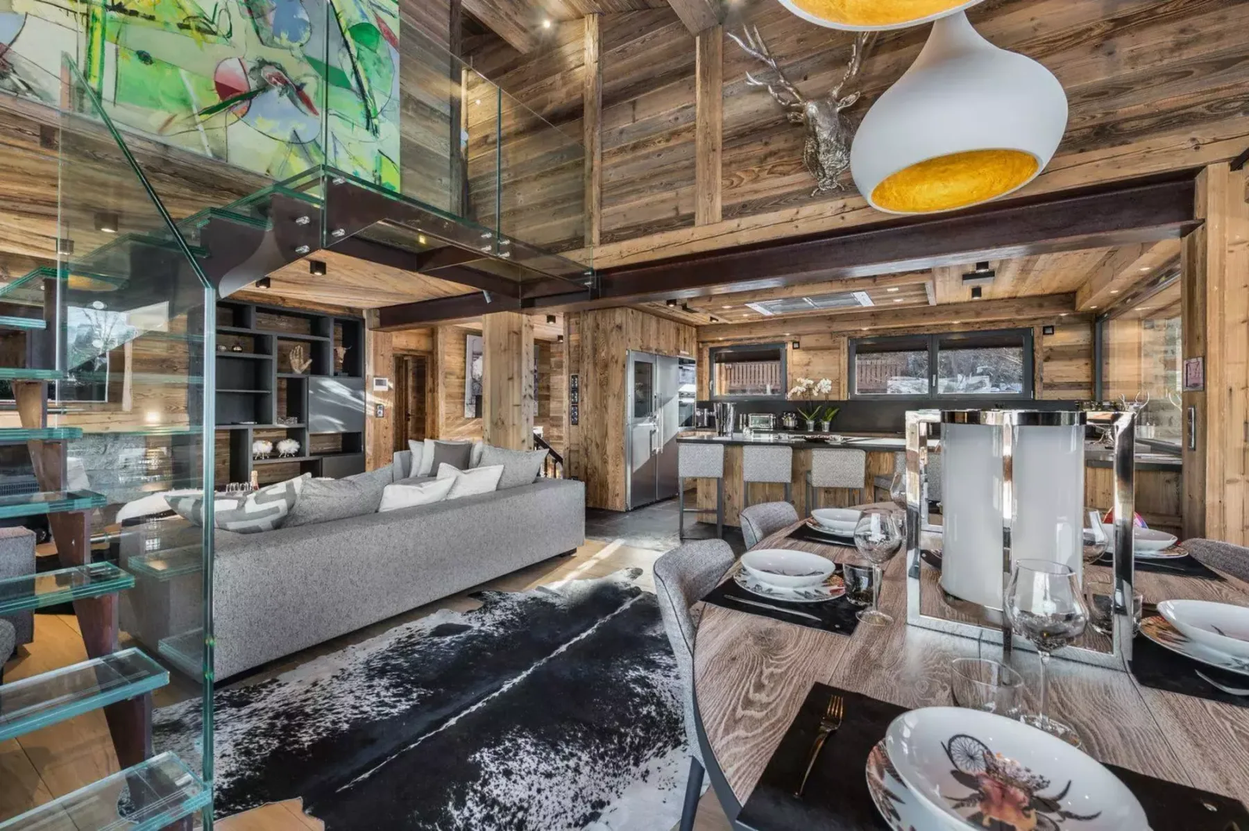 A wood-paneled living and dining area with a kitchen in the background.