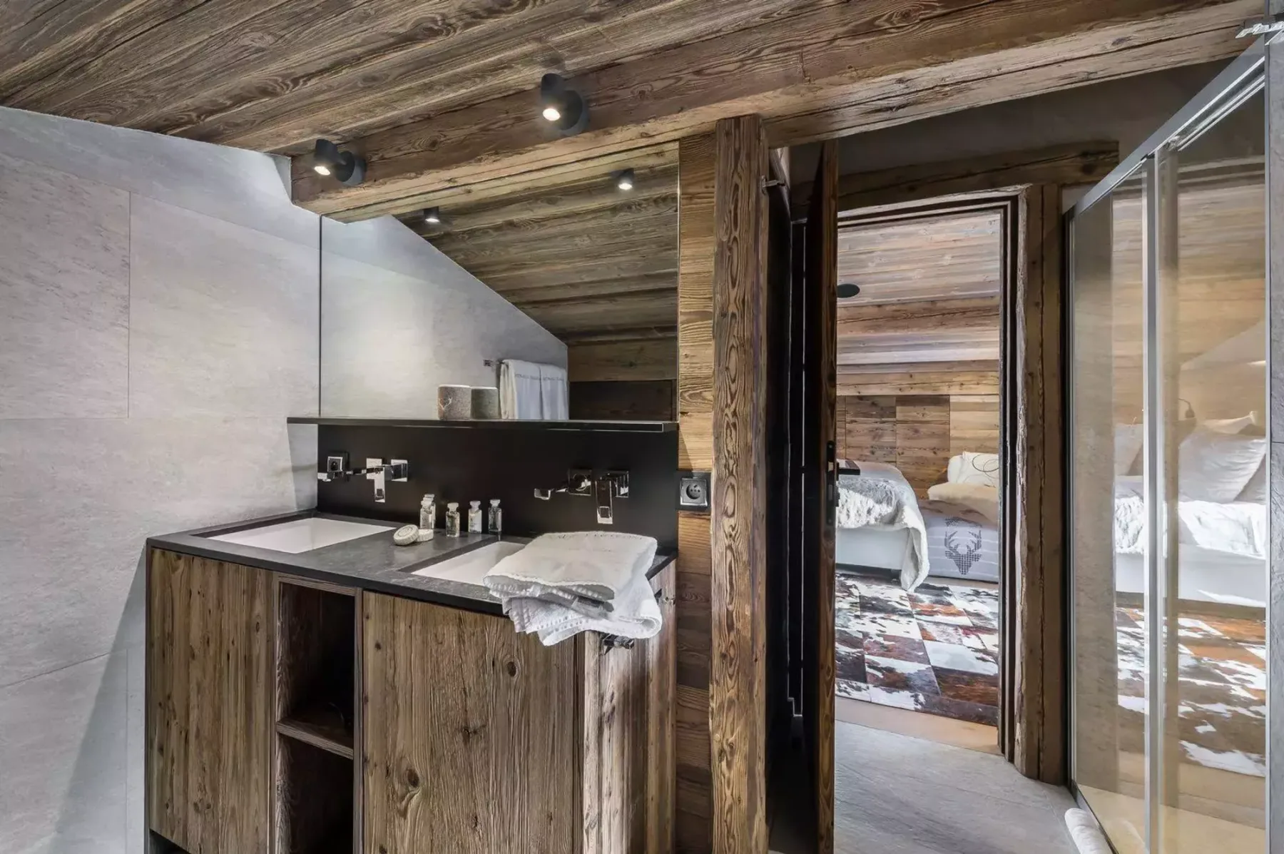 A wood-paneled bathroom with a sink and an open doorway to a bedroom.