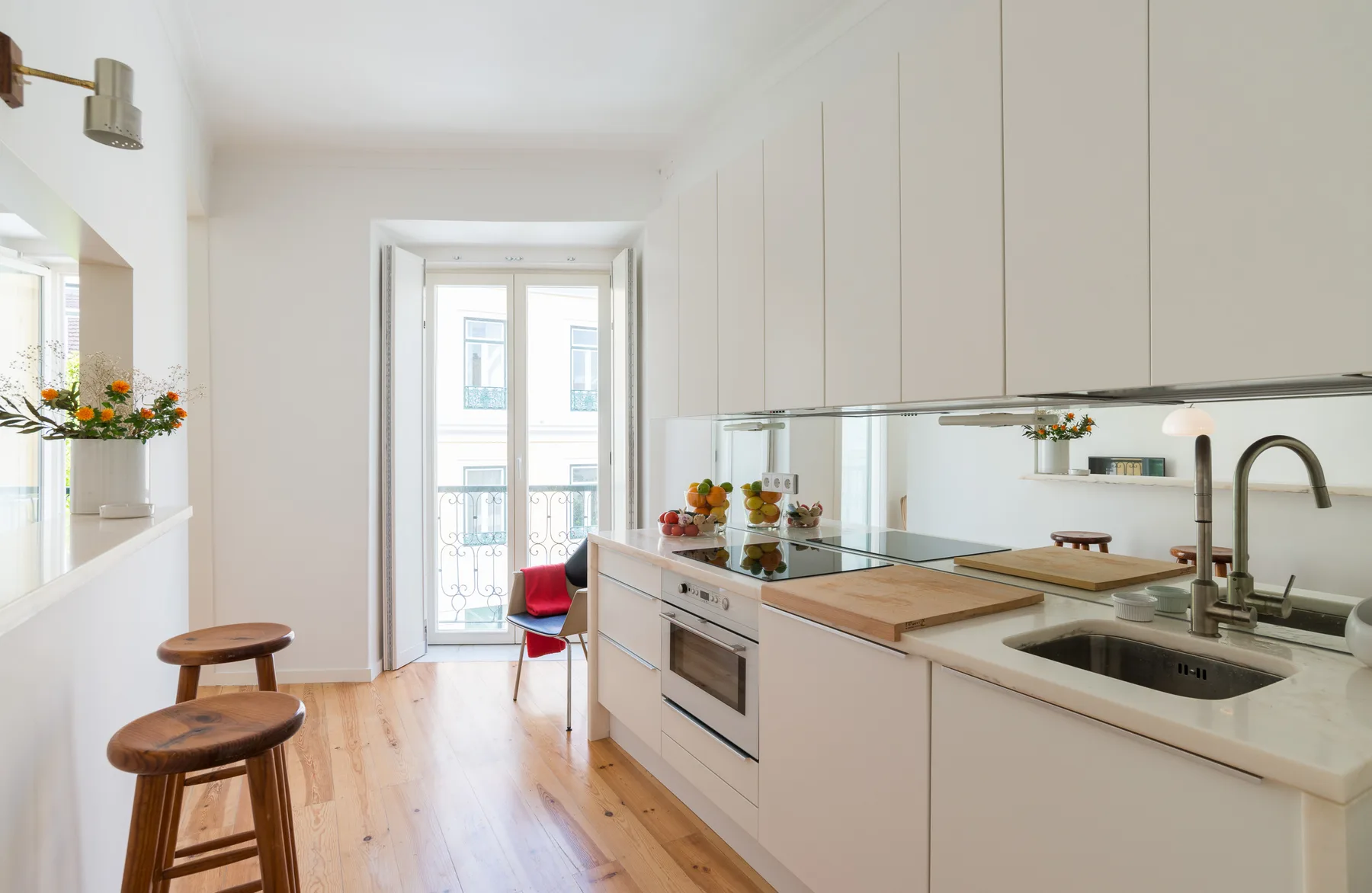Una cocina luminosa con una encimera larga y un rincón para comer junto a la ventana.