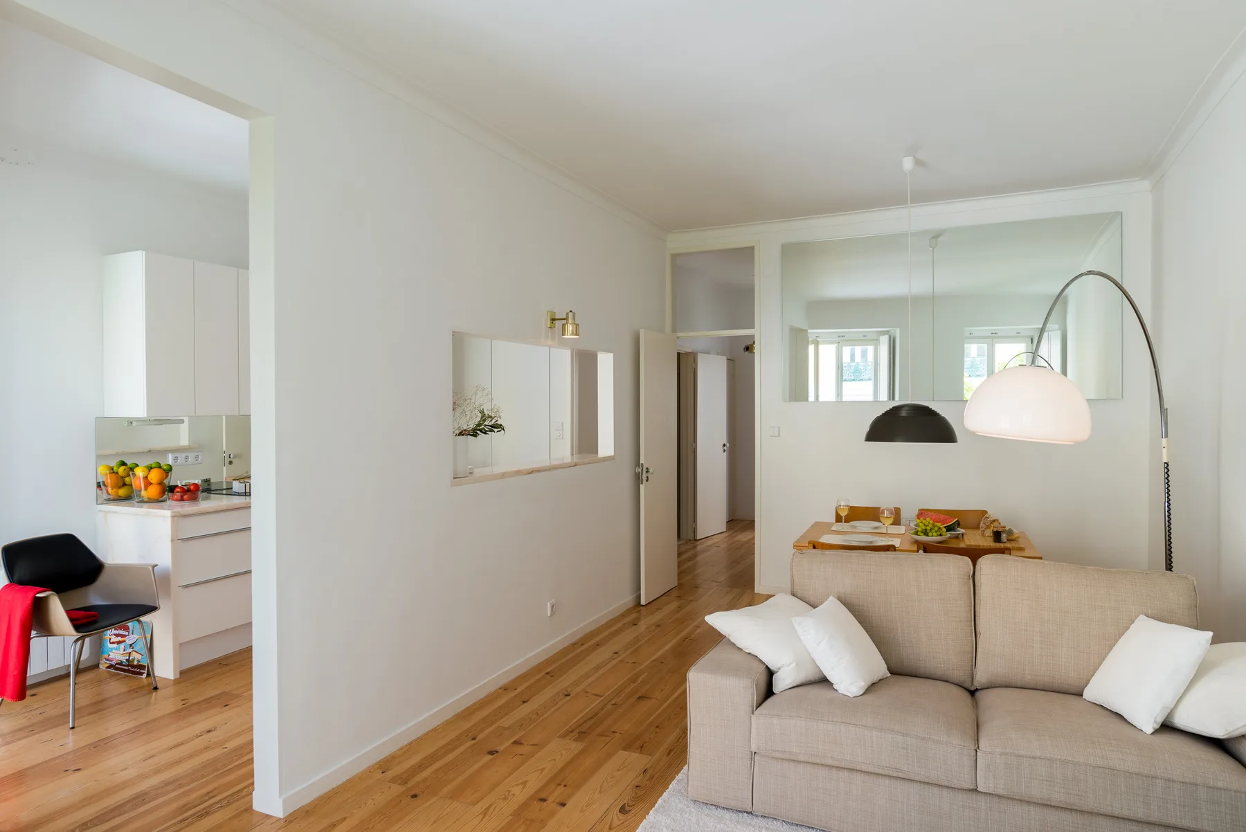 Sala de estar con un sofá beige y vista abierta a la cocina.