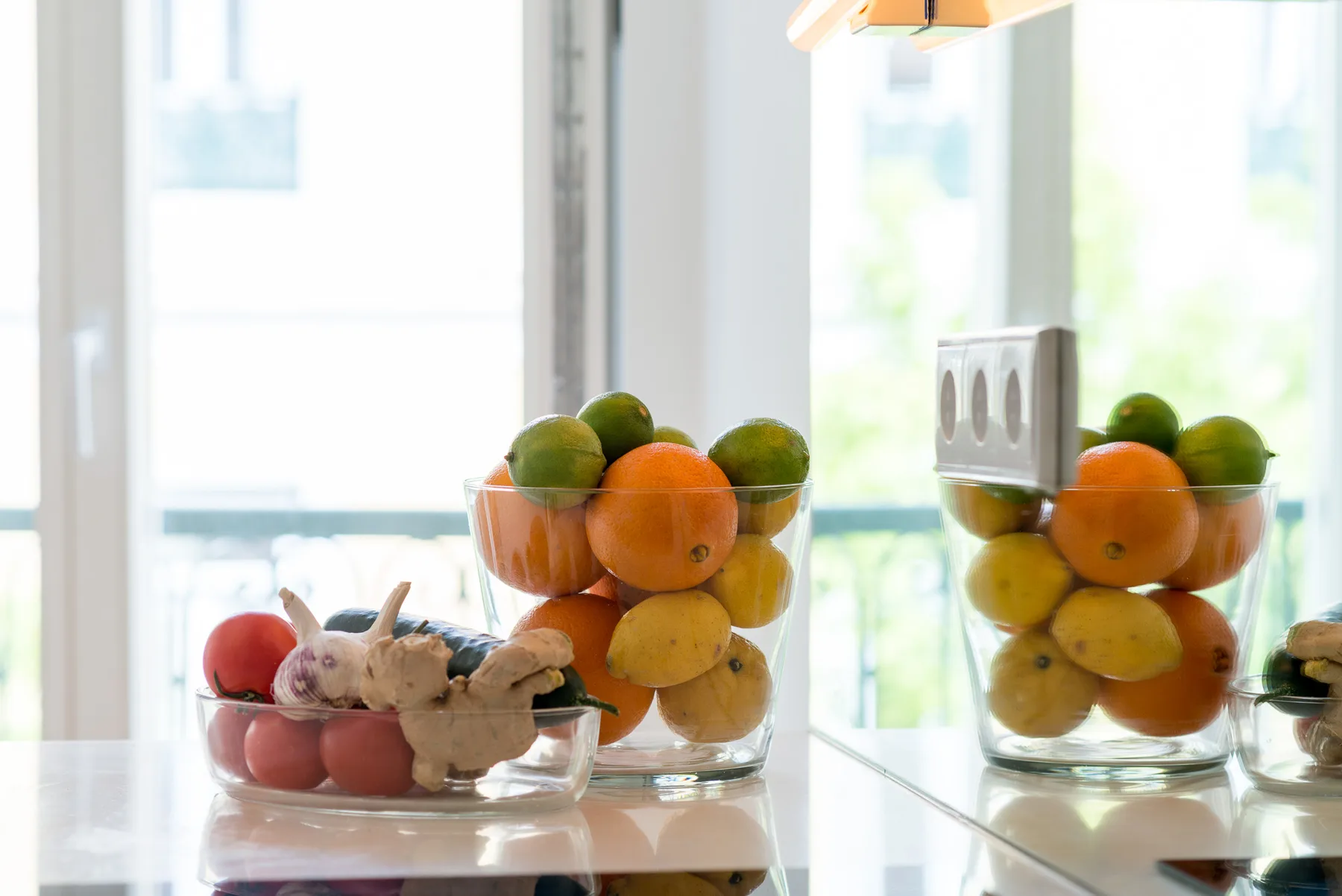 Una encimera de cocina luminosa exhibe cuencos con fruta de varios colores.