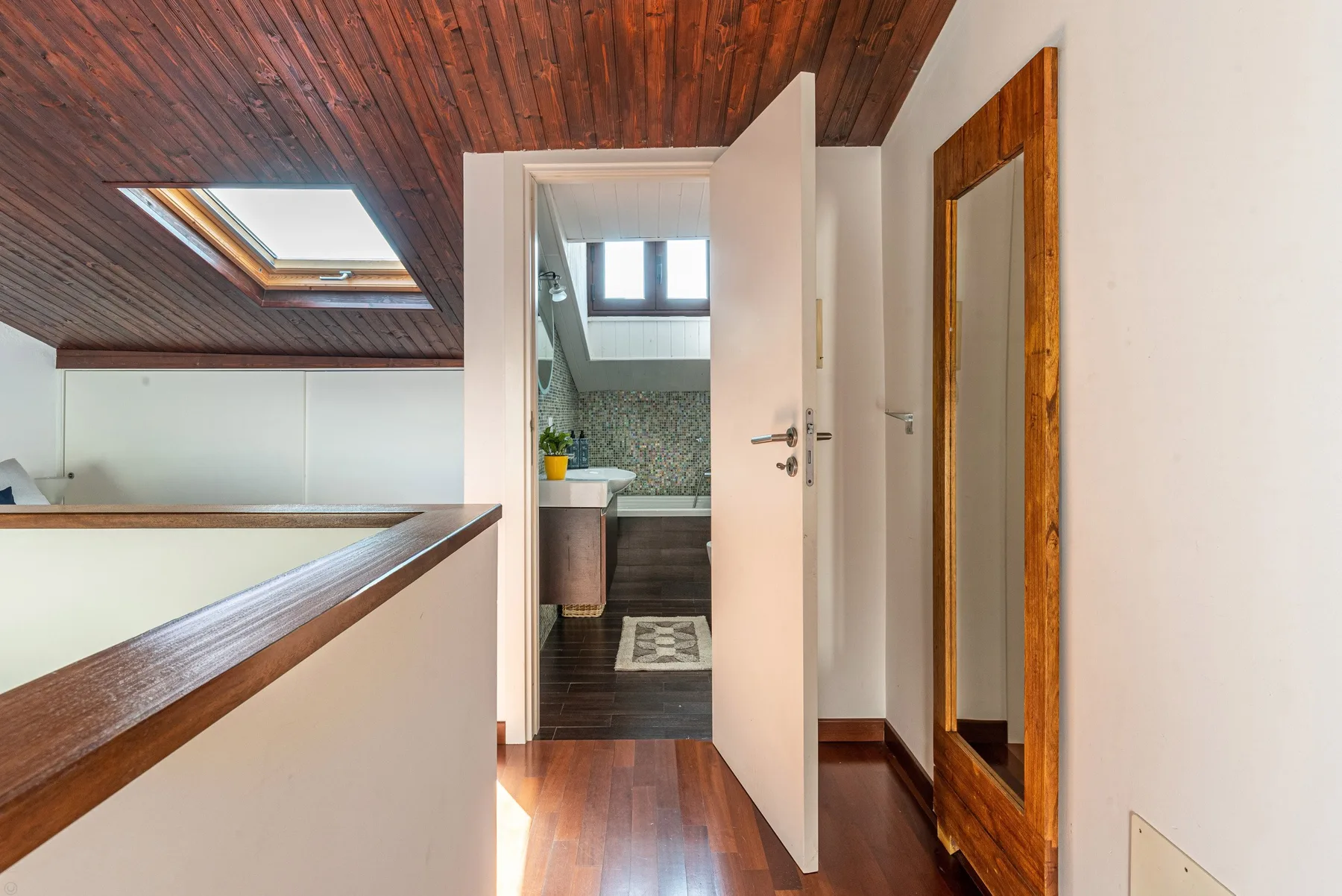 Un pasillo con una puerta abierta que da a un baño.