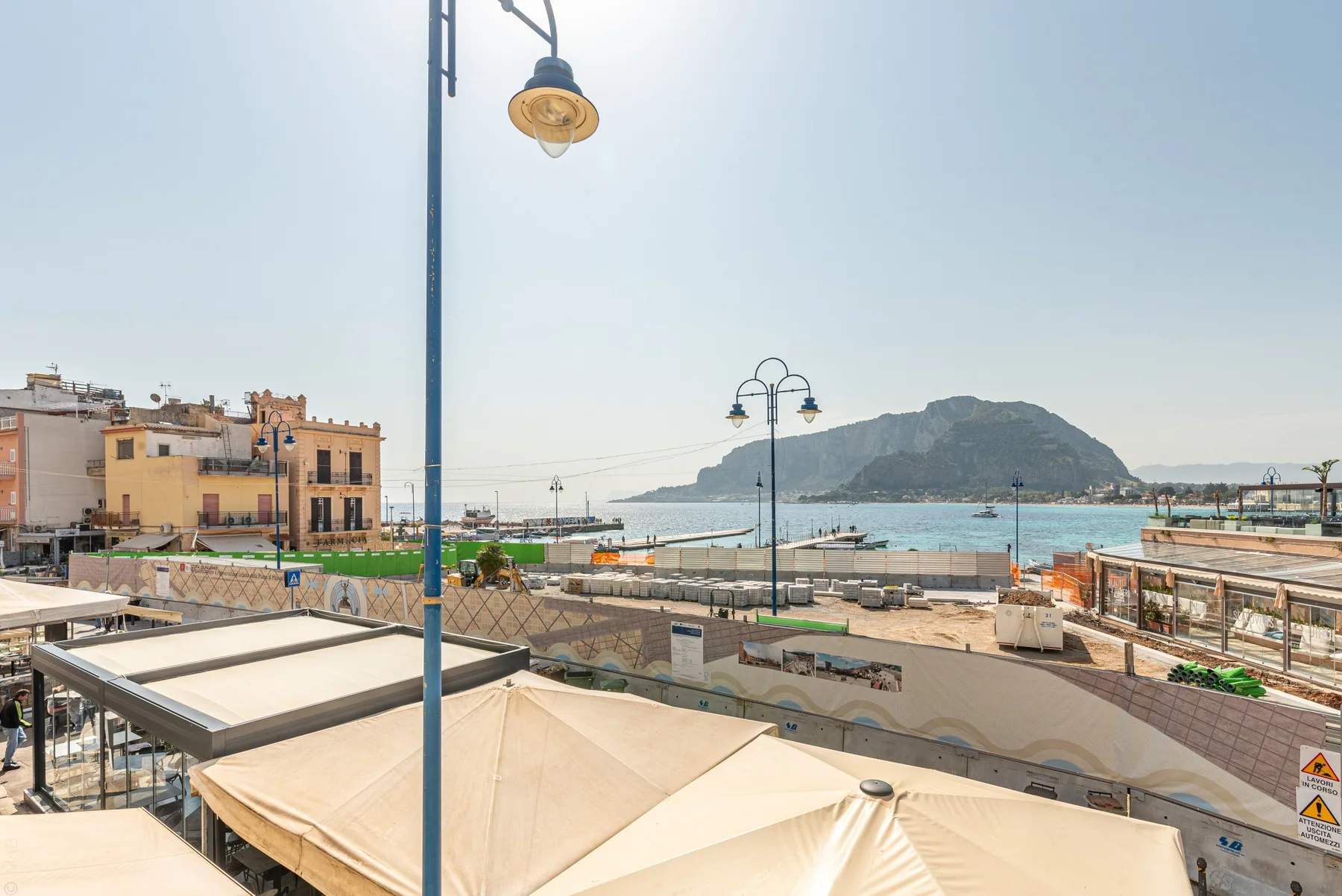 Una terraza junto al mar mira al puerto y a una isla rocosa.