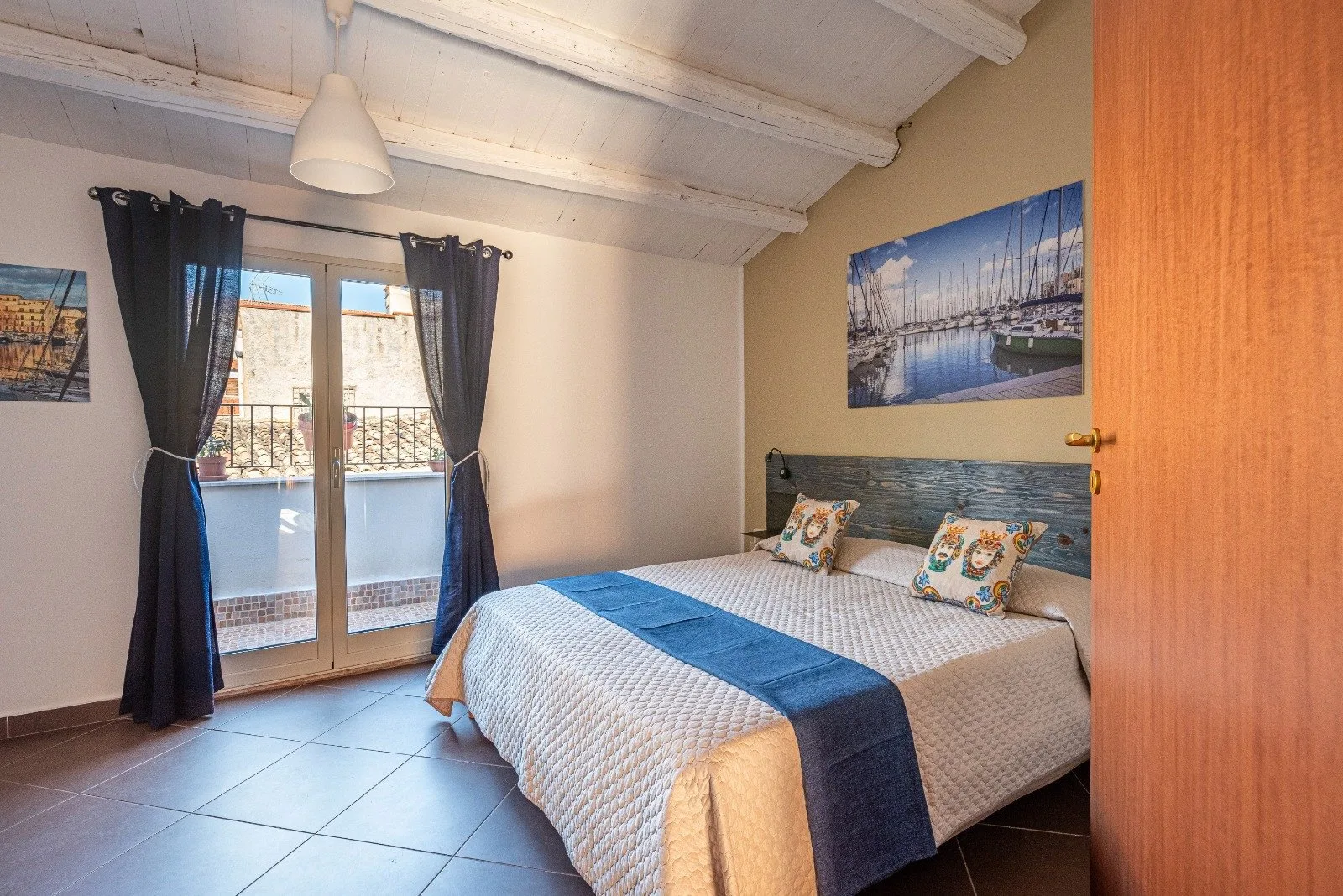 A bedroom with a double bed and glass doors opening onto a balcony.