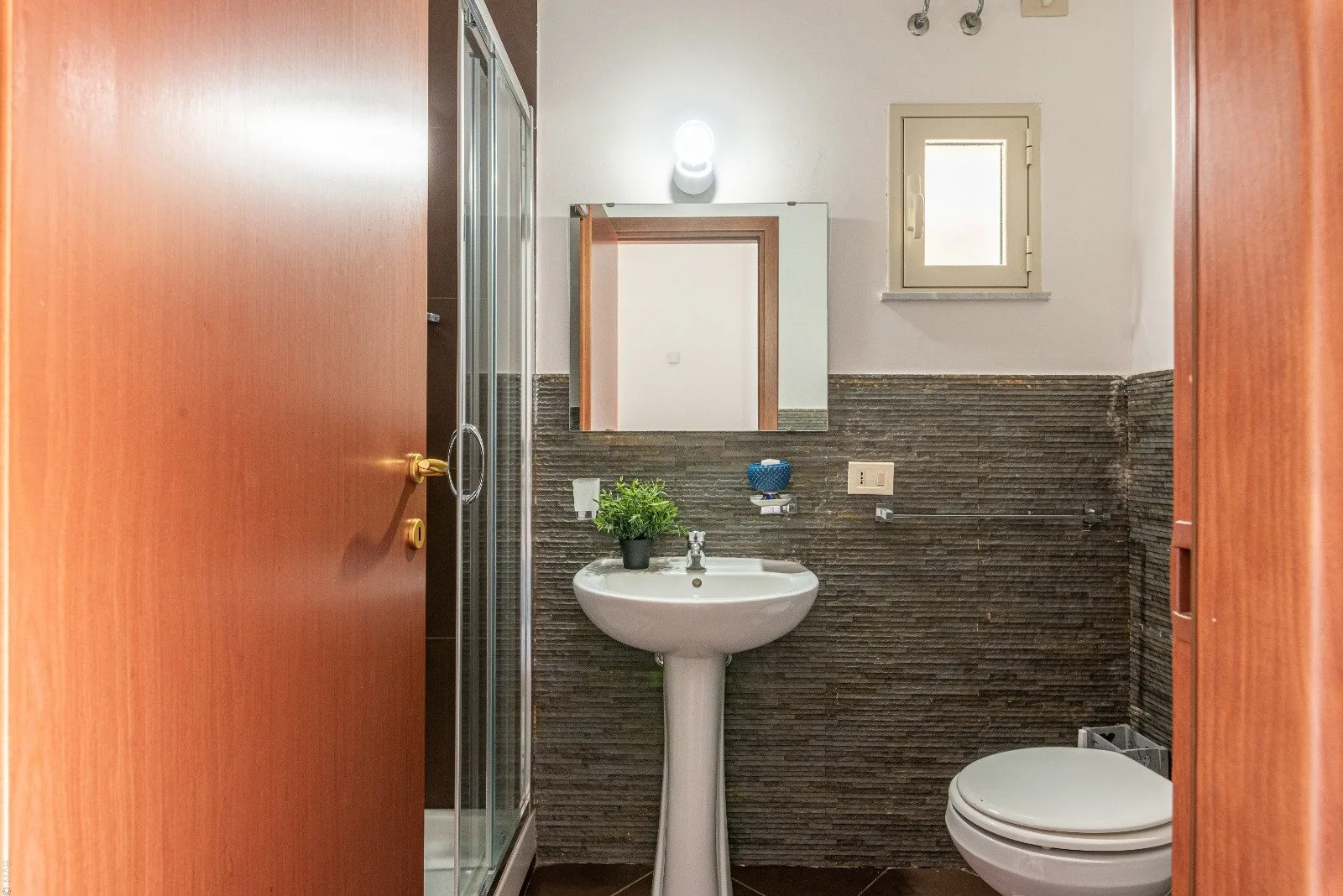 A bathroom with a pedestal sink and toilet.