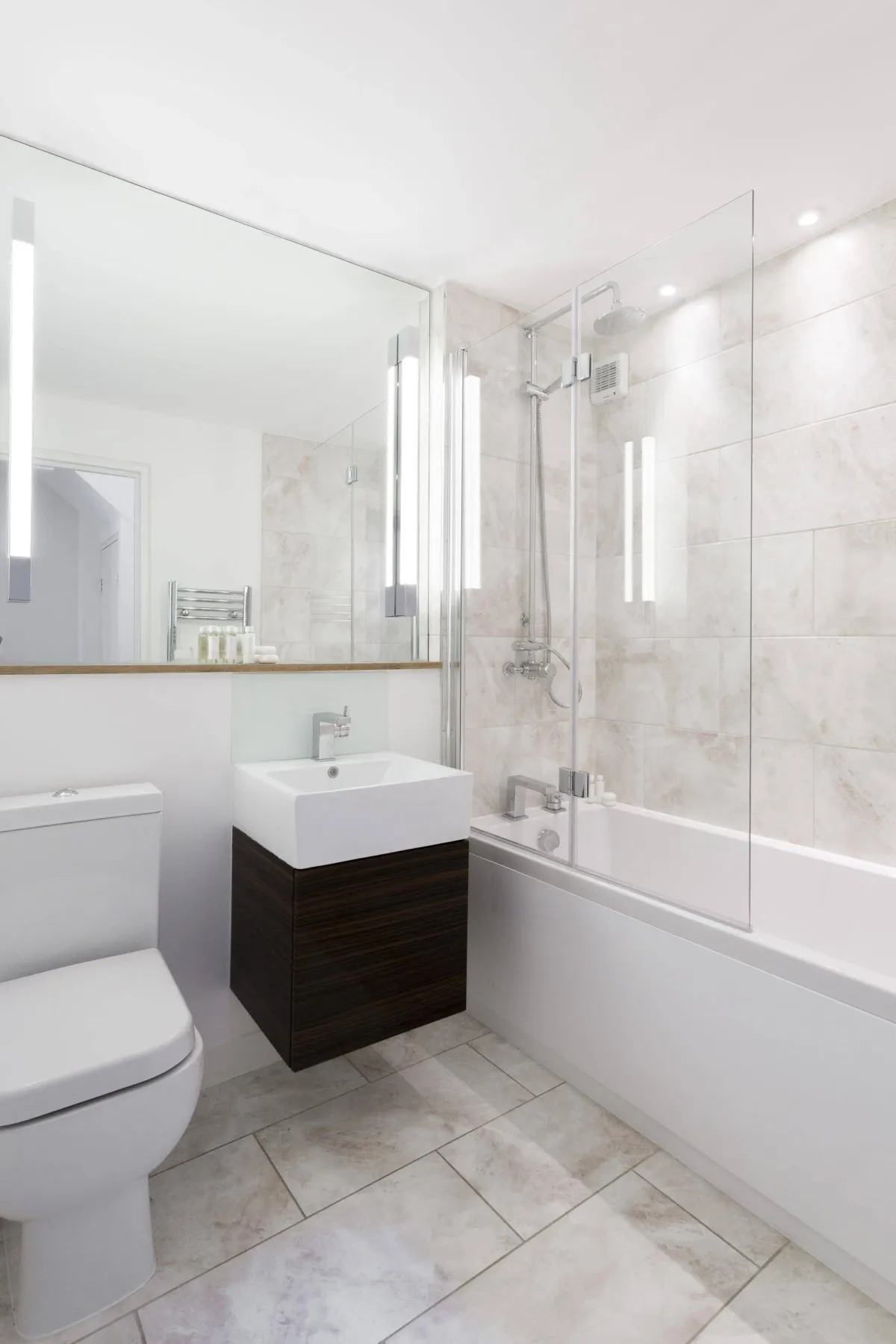 A bright bathroom with a bathtub, shower, sink, and toilet.