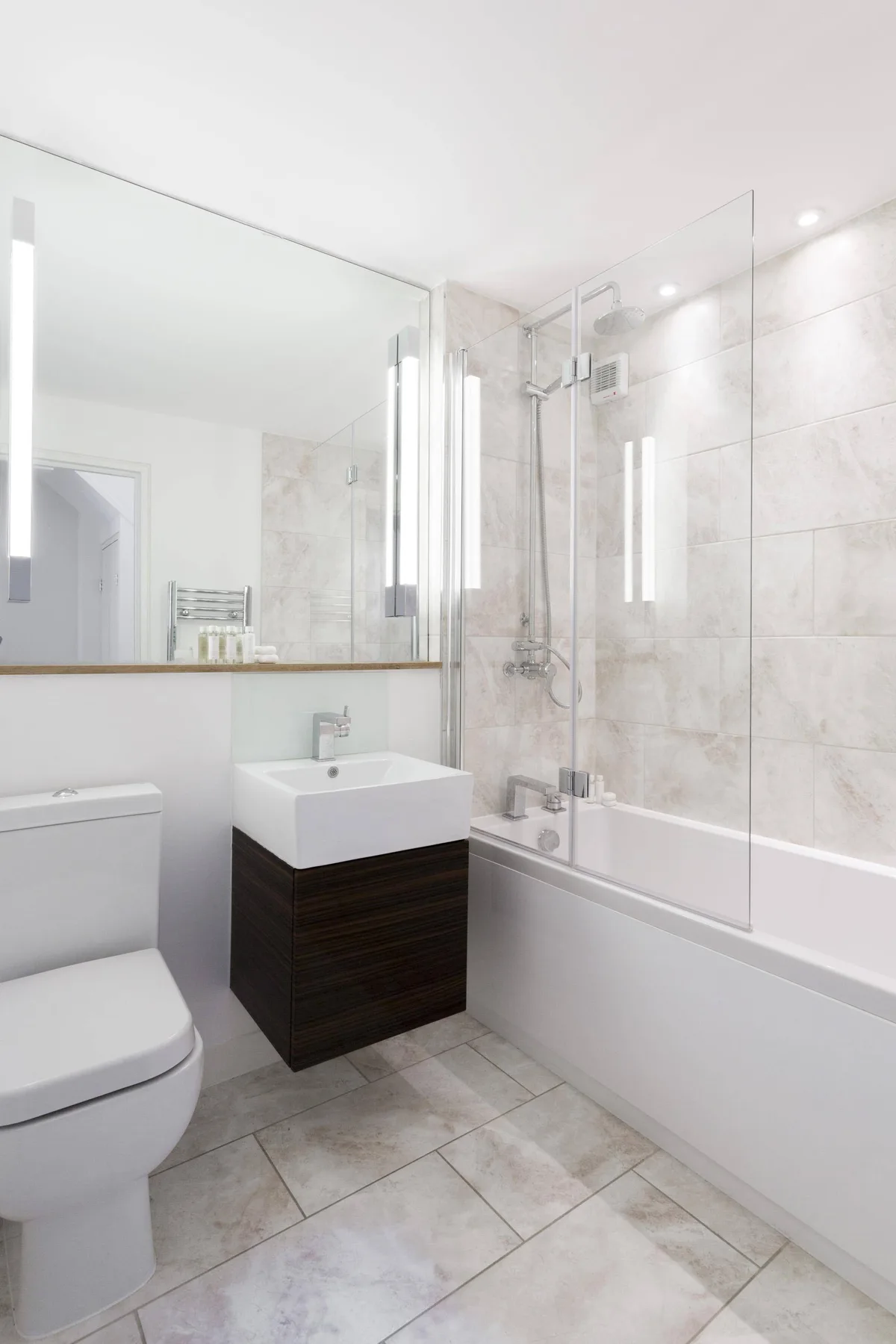 A bright bathroom with a bathtub, shower, and wall-mounted mirror.