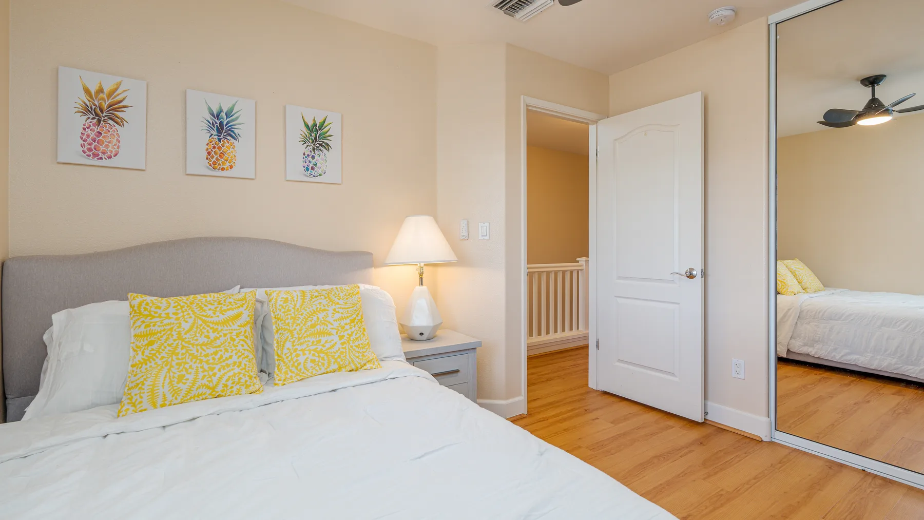 A bedroom with a bed, bedside lamp, and open doorway.
