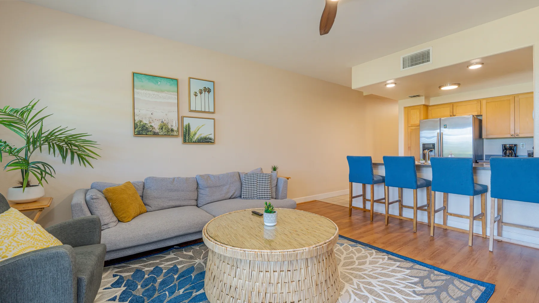 A living room with seating, a round coffee table, and an open kitchen area.