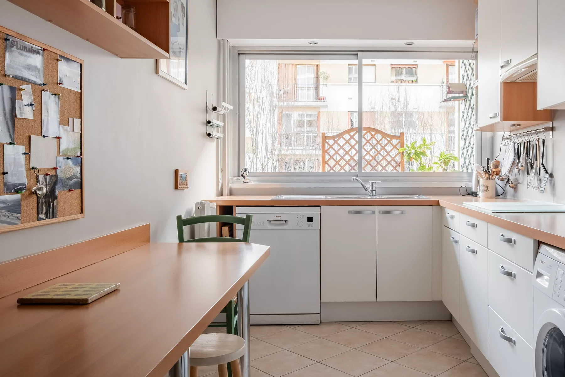 A bright kitchen with a dining table beside the window.