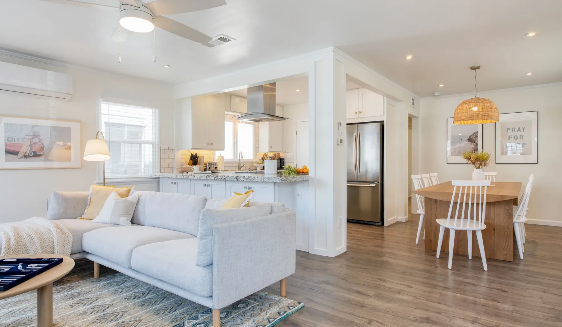 Sala de estar y cocina de planta abierta, con una mesa de comedor junto al sofá.