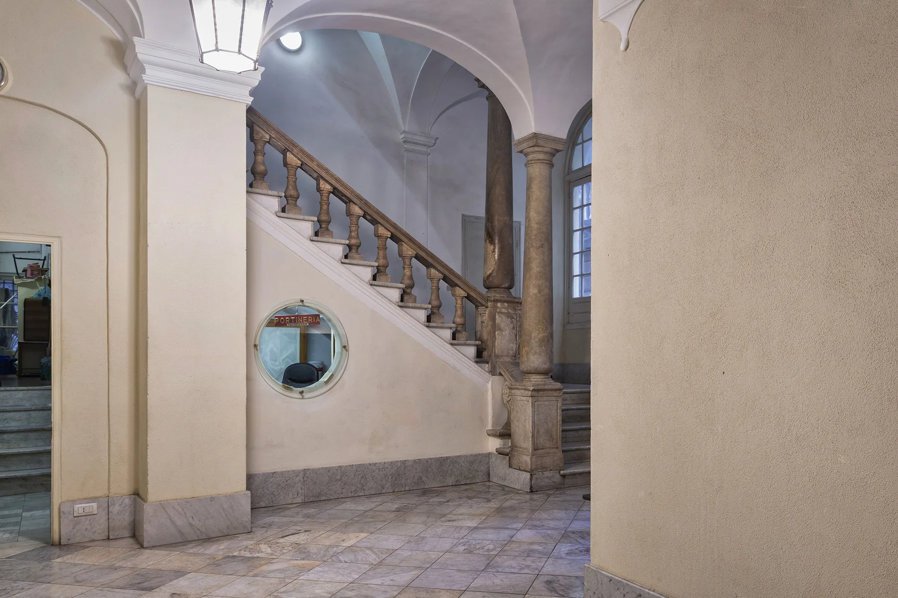 Un elegante vestíbulo interior con una escalera curva y un pasaje arqueado.