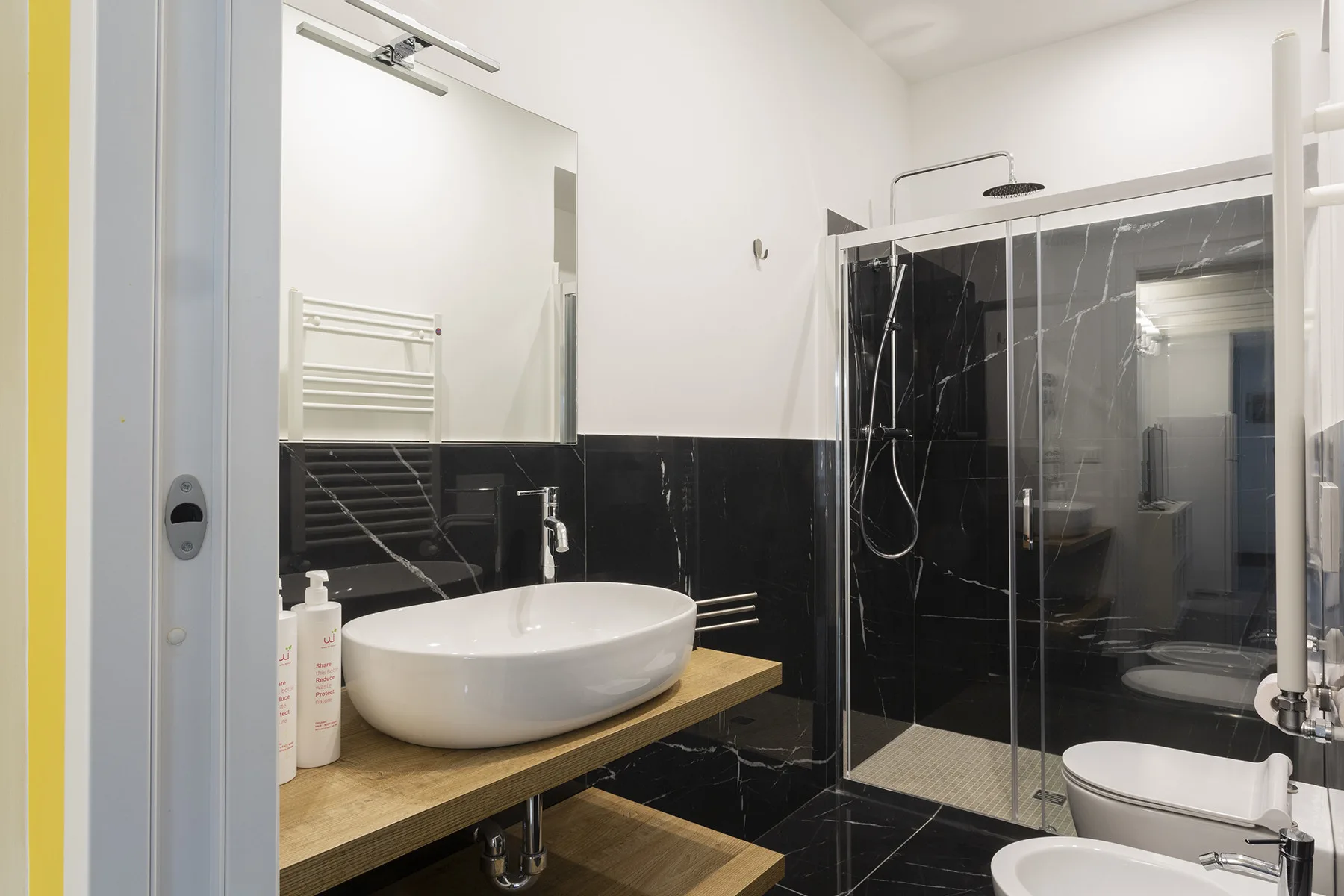 Un baño con un lavabo junto a una ducha de cristal.