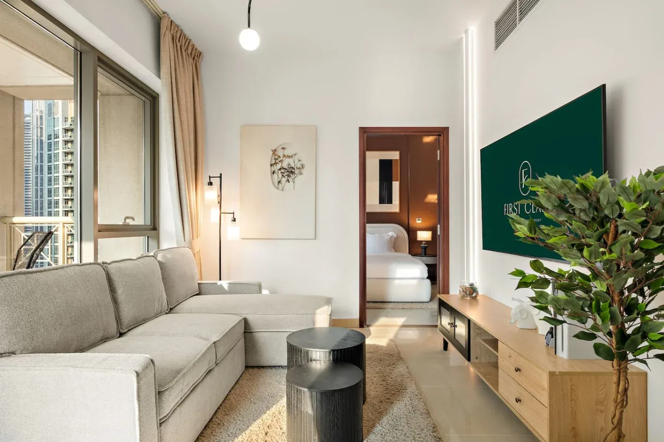 Una sala luminosa con asientos, una mesa baja y una ventana grande.