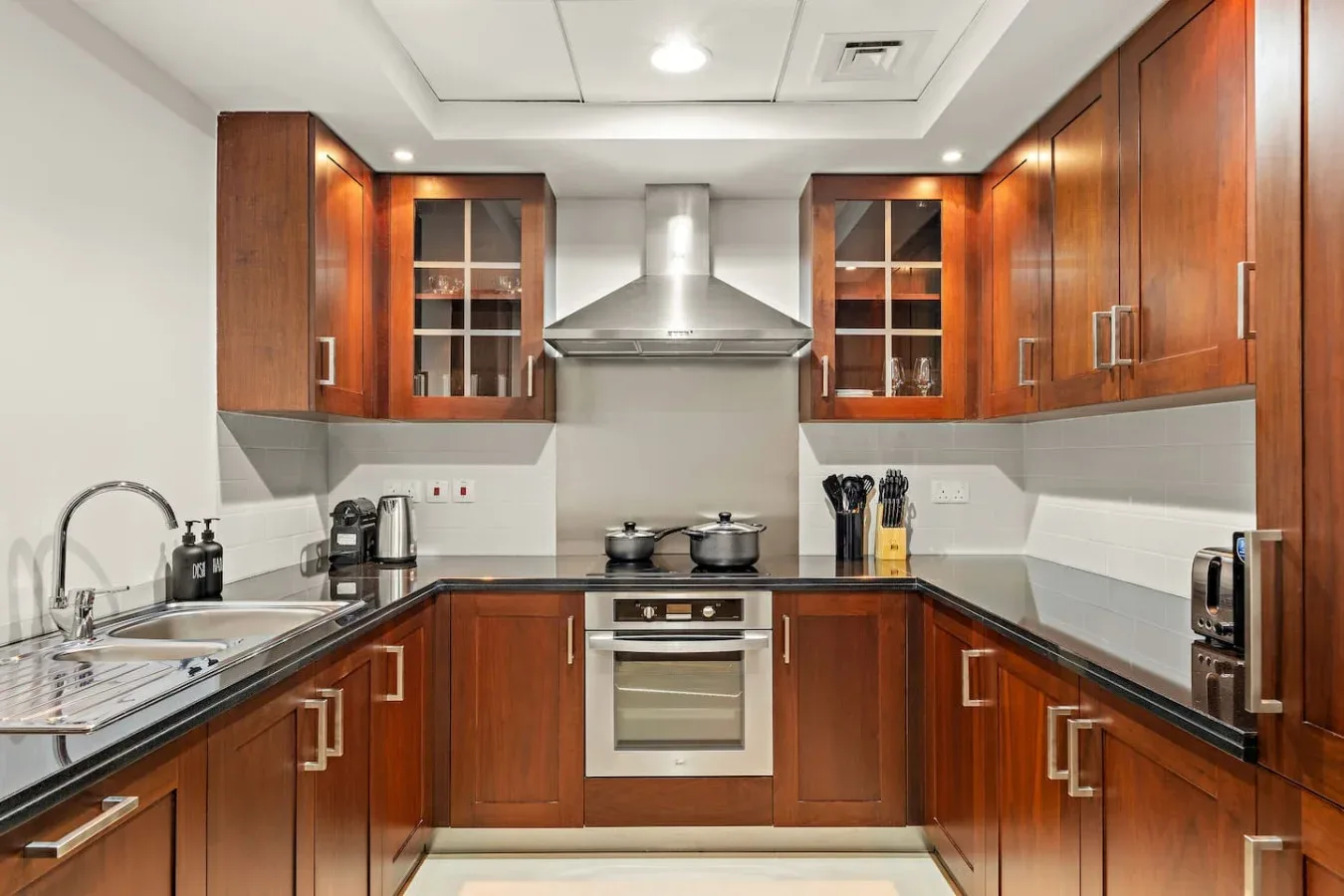 Una cocina con gabinetes de madera, encimeras y una estufa central.