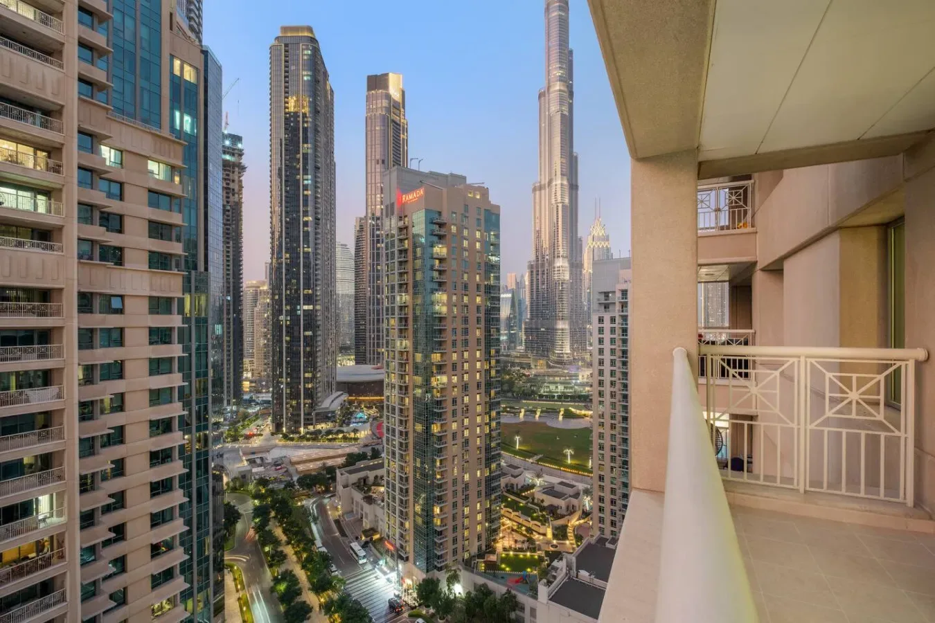 A city skyline viewed from a balcony, with tall buildings beyond the railing.