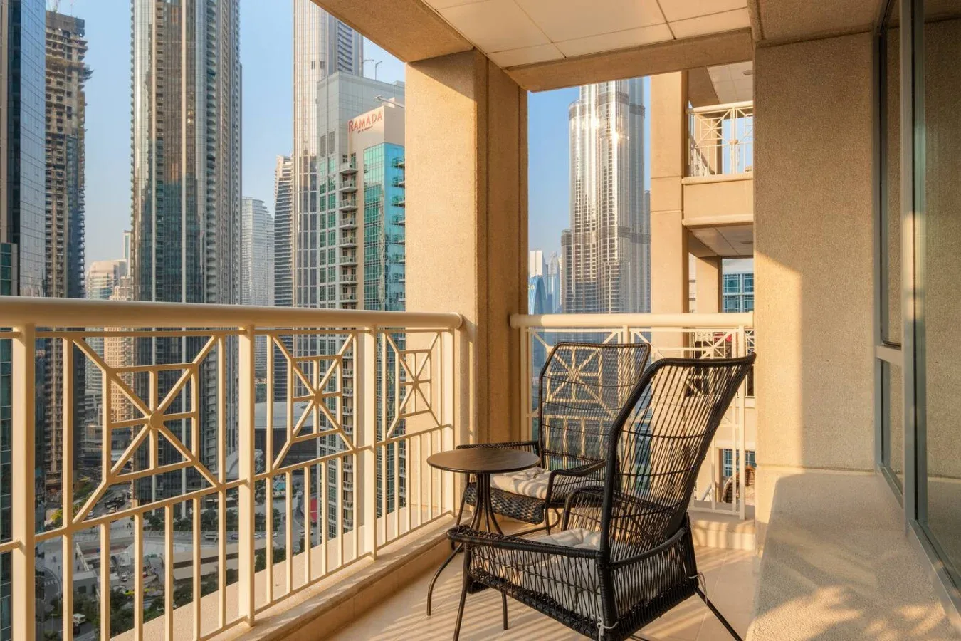 Una zona de estar en un balcón ofrece vistas a varios edificios altos de la ciudad.