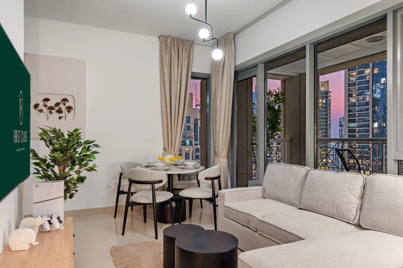 Una sala de estar con asientos junto a una mesa de comedor y grandes ventanas.