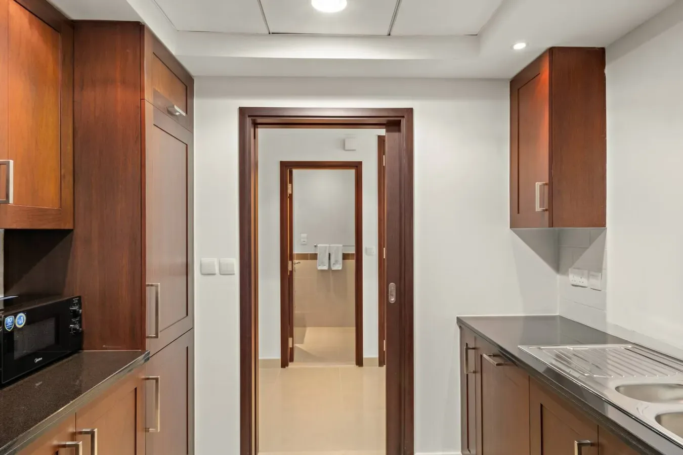 Una cocina con gabinetes de madera y una encimera junto a la pared.