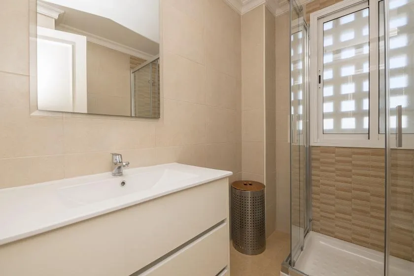 A bathroom with a sink, mirror, and glass shower.