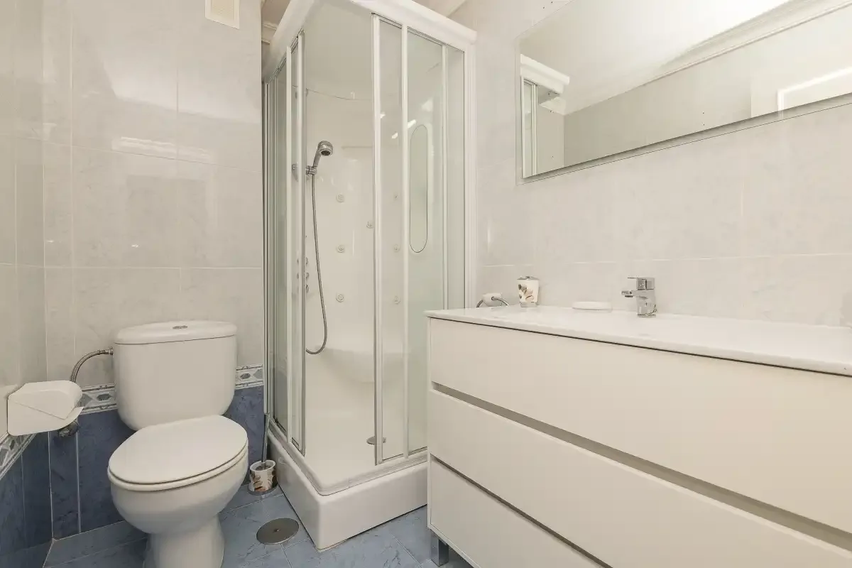 A bathroom with a shower, toilet, and sink vanity.