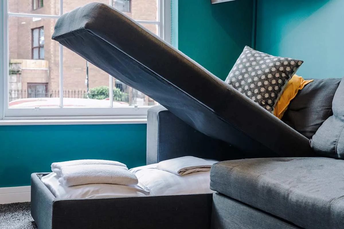 A living room seating area with a raised sofa bed beside a large window.