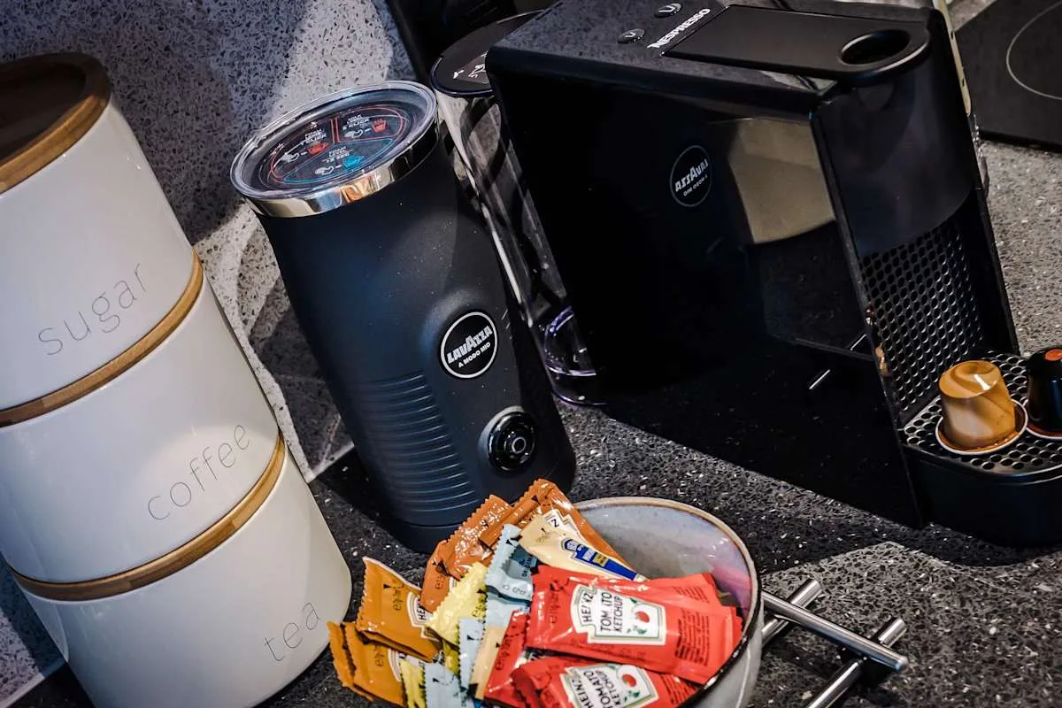 A kitchen counter with a coffee machine, grinder, and coffee supplies.