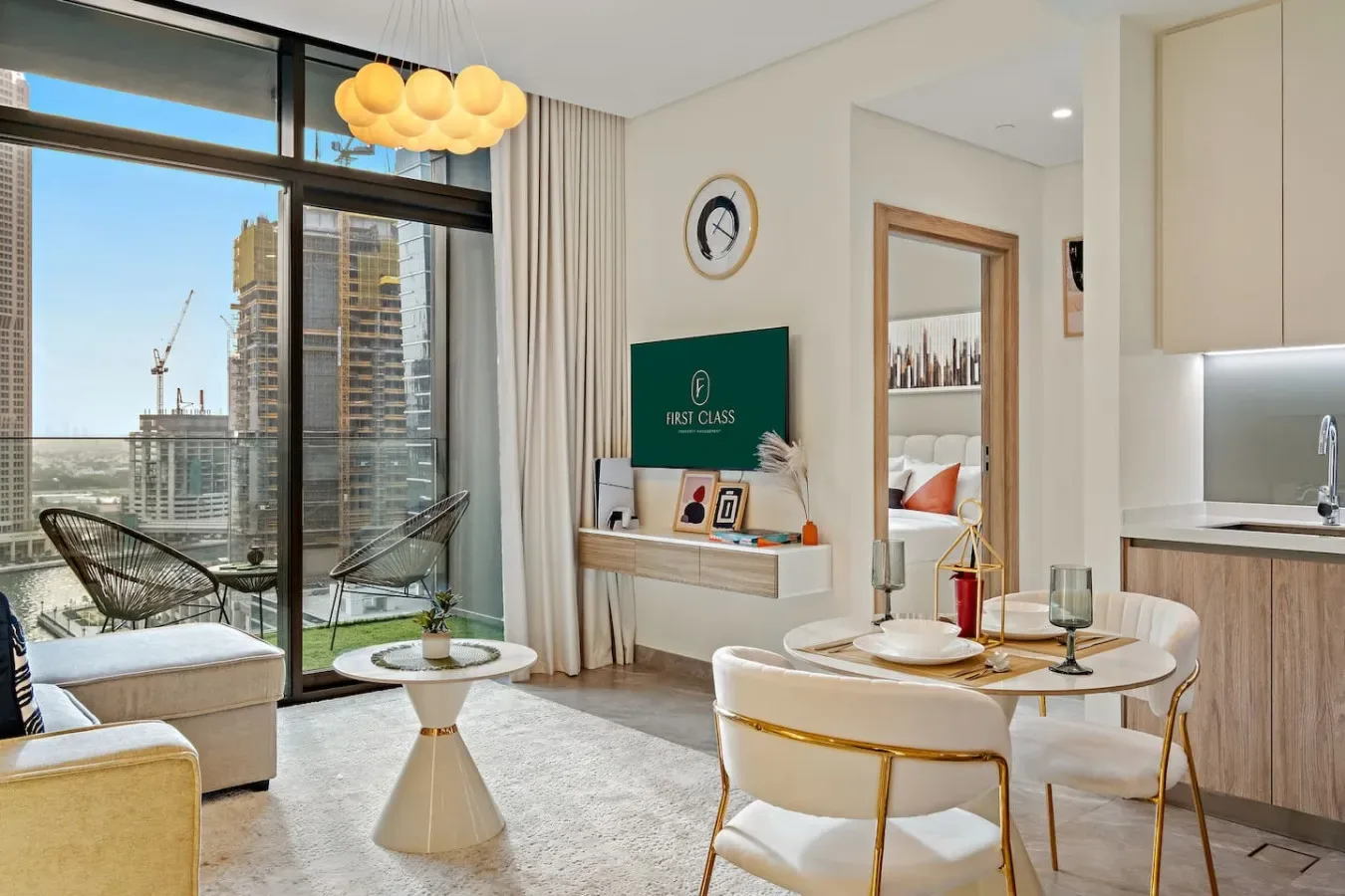 Una luminosa sala de estar y comedor da a un balcón, con edificios visibles en el exterior.