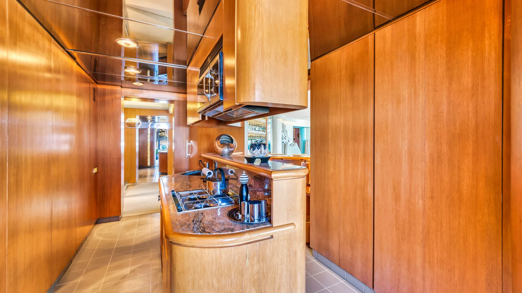 A wood-paneled kitchen with a curved island and built-in cooktop.