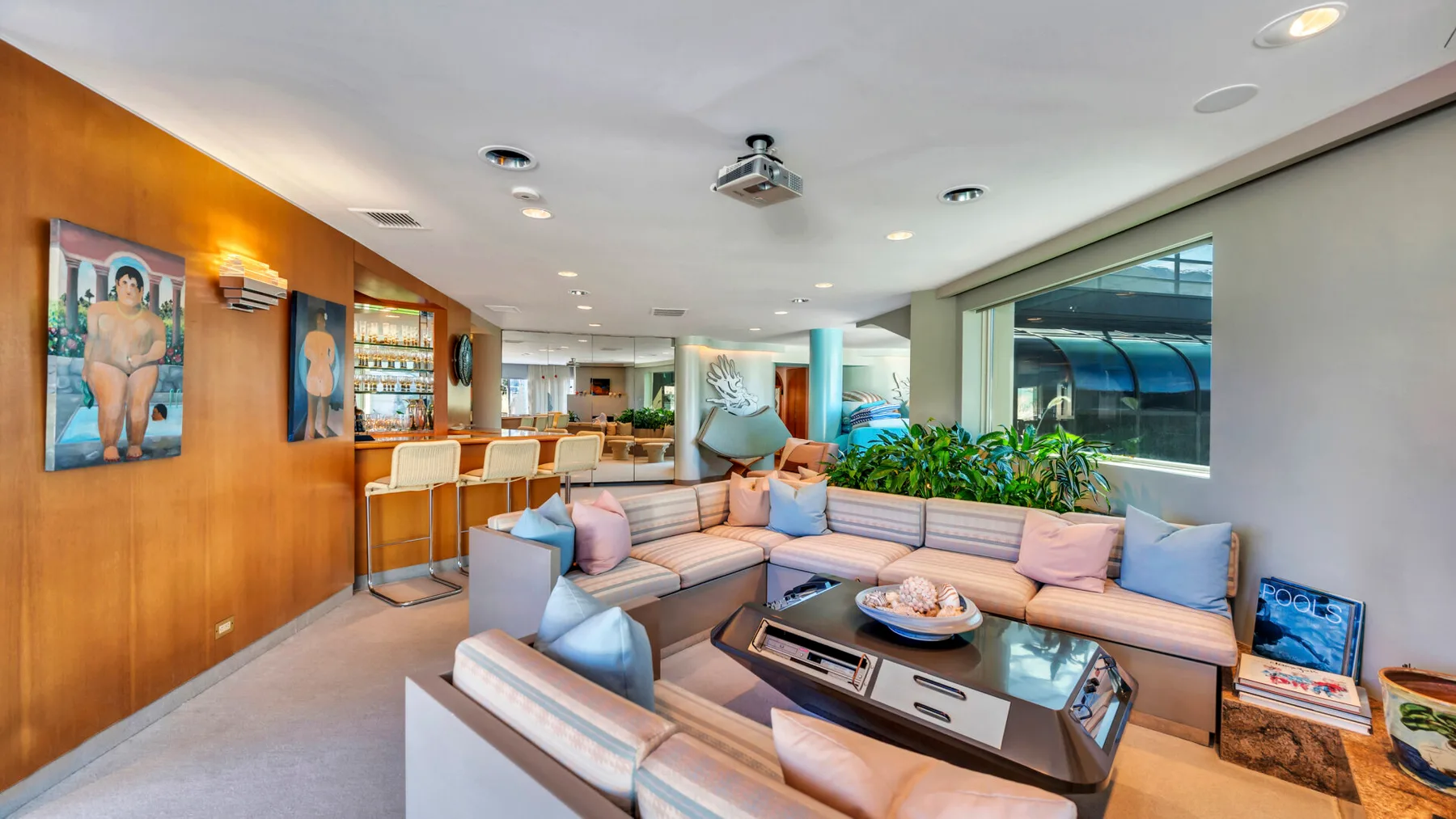 A lounge with sectional seating, a low coffee table, and large windows.