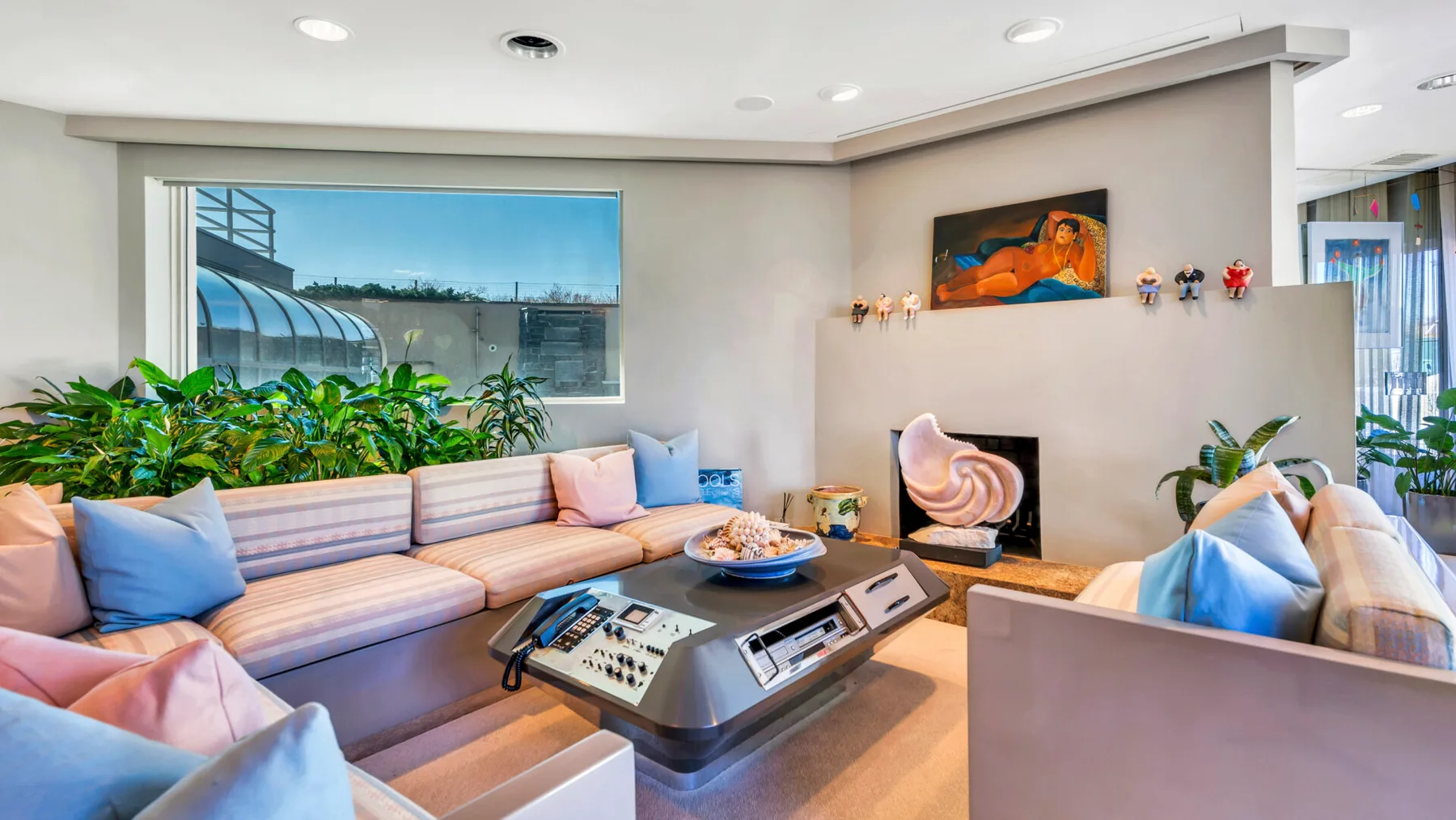 A bright living room with sectional seating, a low table, and wall art.