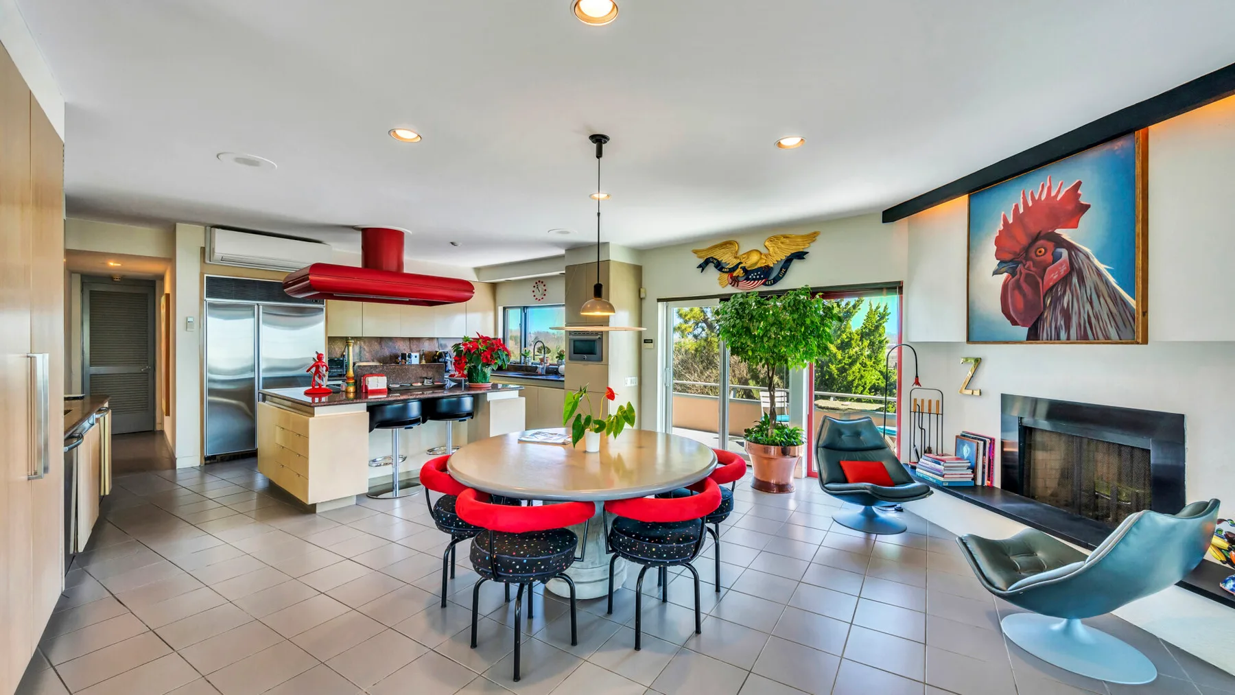 An open kitchen and dining area has a round table beneath a pendant light.