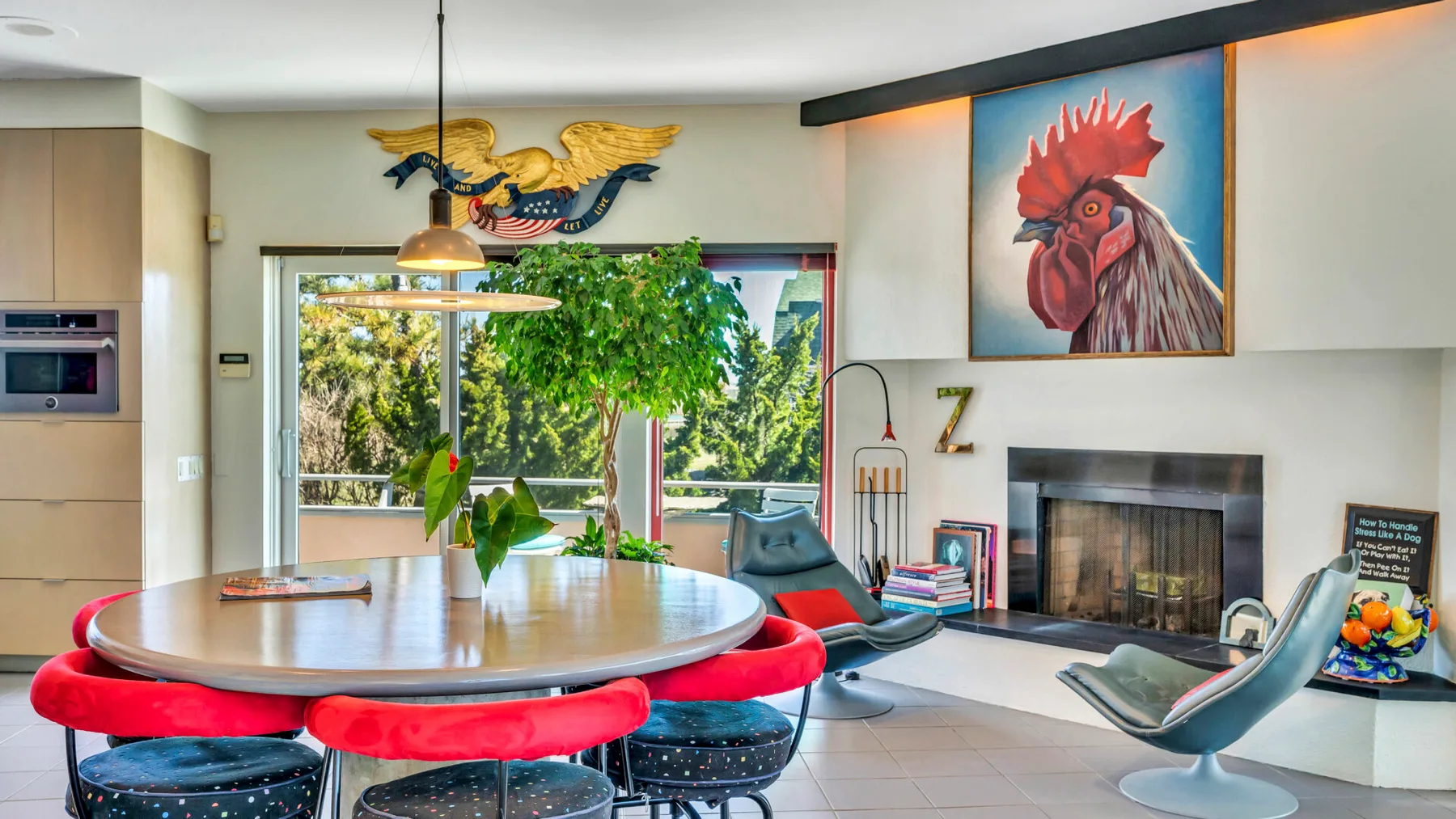 A bright dining and living area features a round table, seating, and a fireplace.
