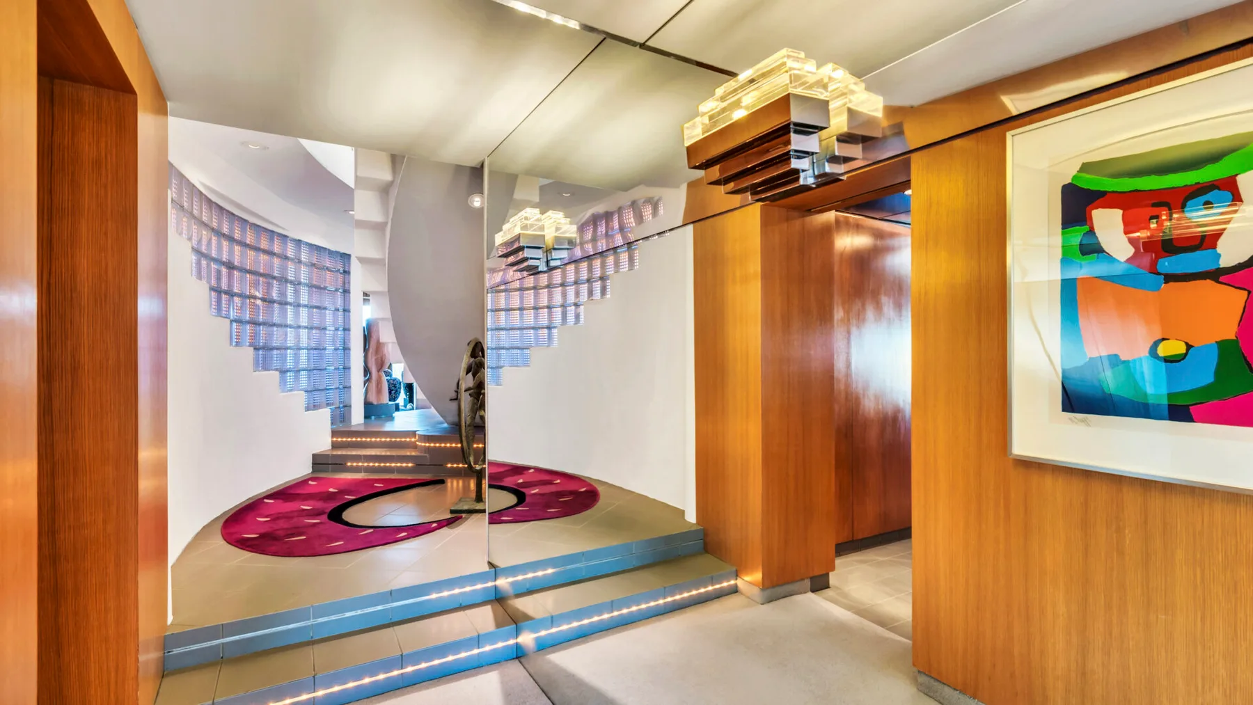 A wood-paneled interior opens onto a mirrored hallway with a colorful floor design.