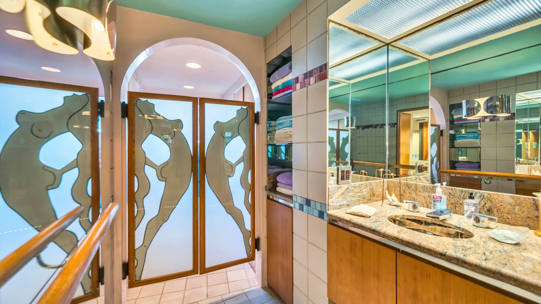 A bathroom vanity with a long counter, sinks, and a large mirror.