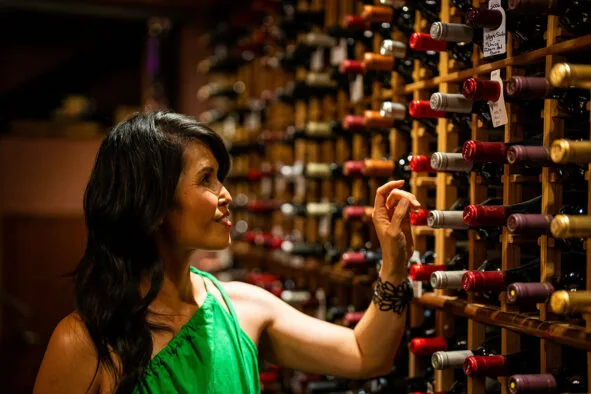 Guest selecting a bottle in the wine cellar