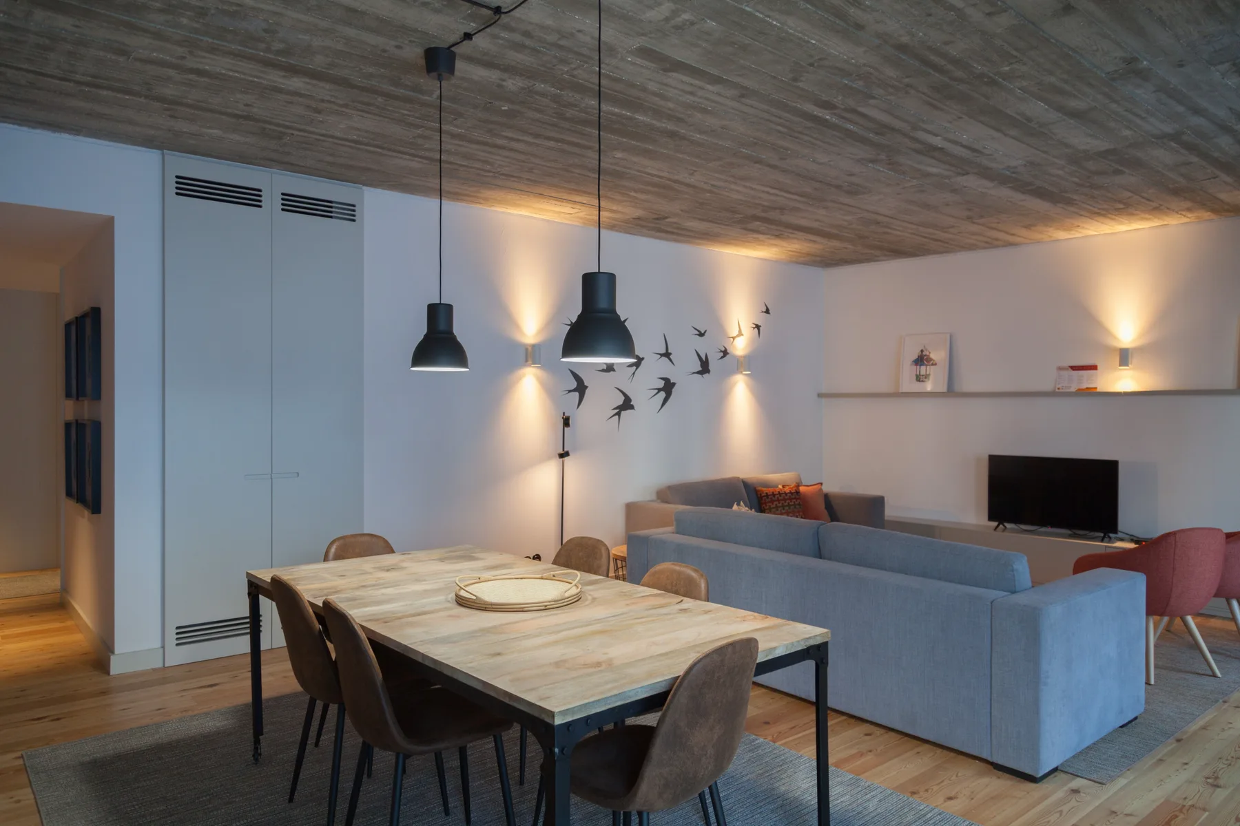 An open-plan living and dining area with a table, seating, and television.