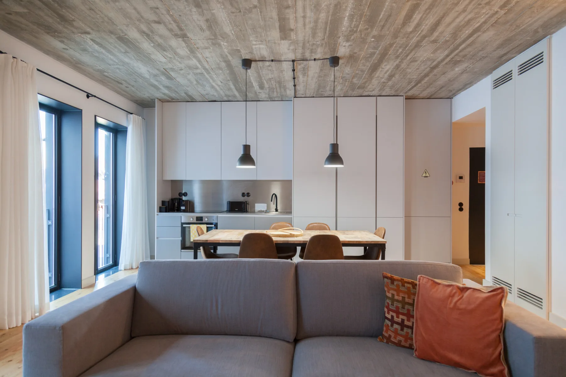 An open-plan living and kitchen area with a sofa and dining table.