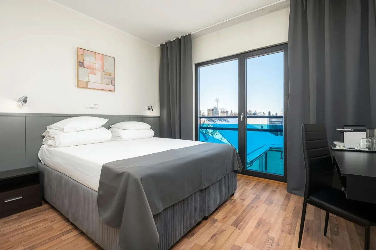 Habitación doble estándar con cama amplia y sofá cama