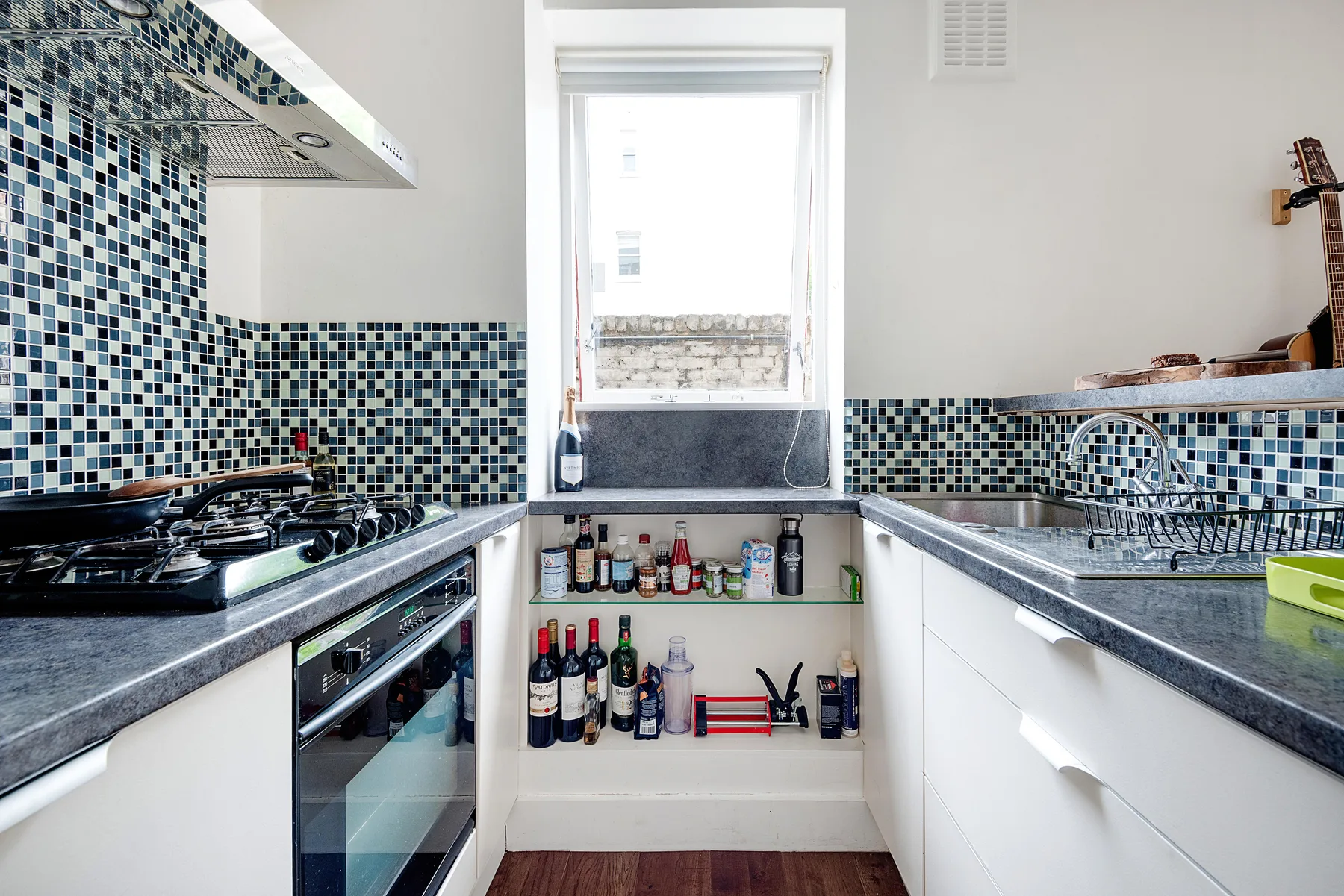 Una cocina luminosa con salpicadero de azulejos, encimeras y una ventana.