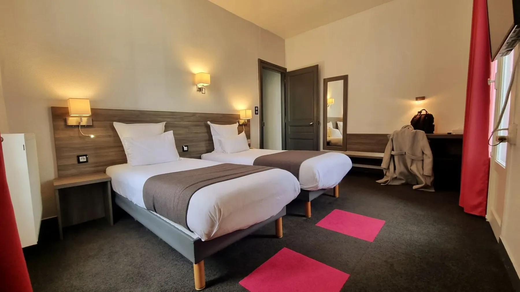 Twin room with pink curtains and gray bedspread