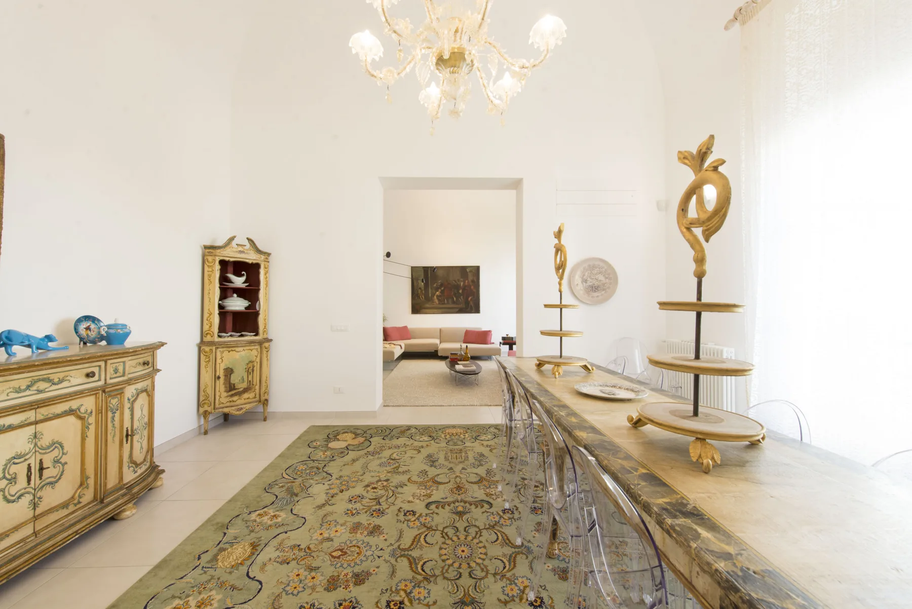 Un comedor luminoso con una mesa larga y muebles ornamentados.