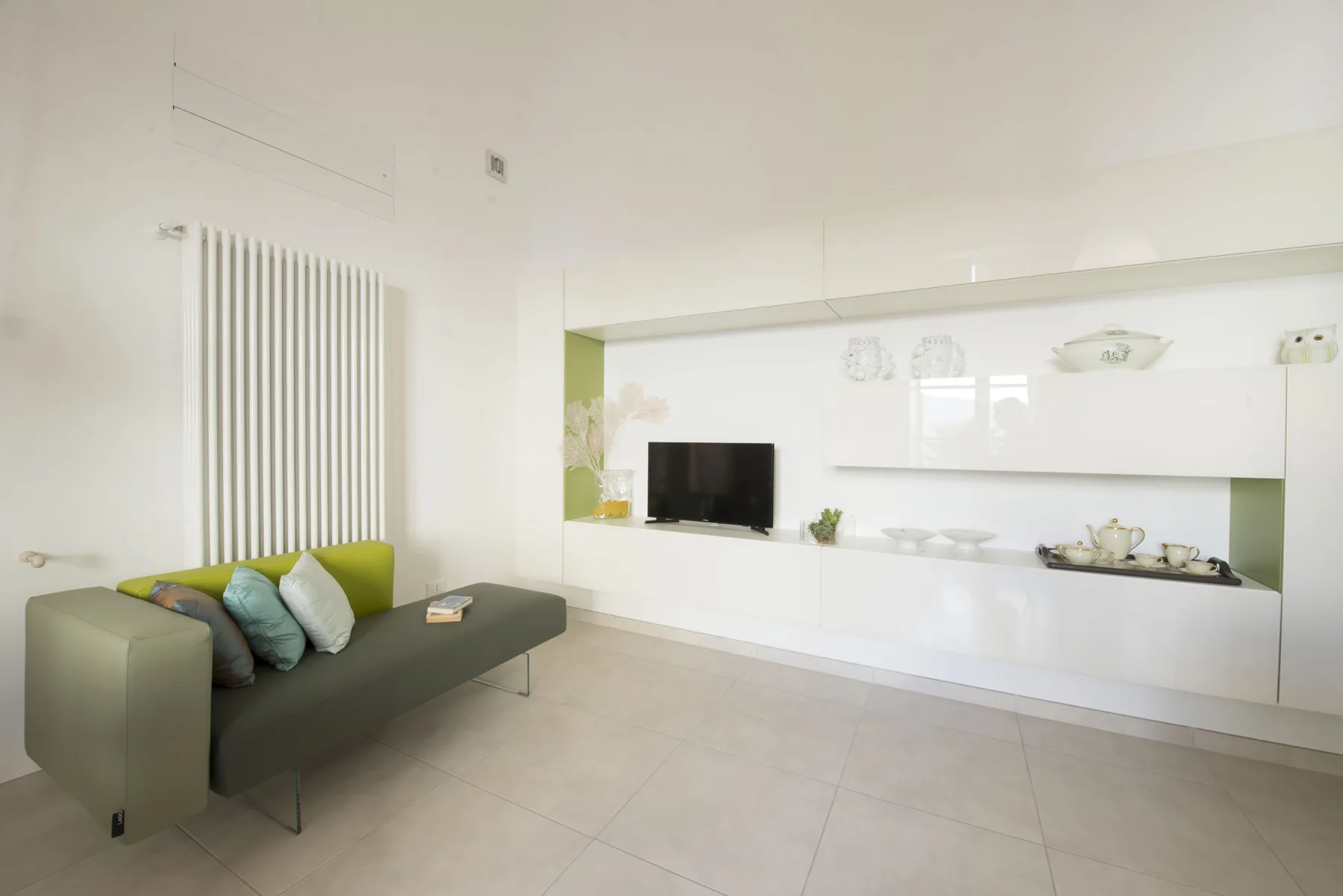 Una sala luminosa con una zona de asientos baja y estantes empotrados.
